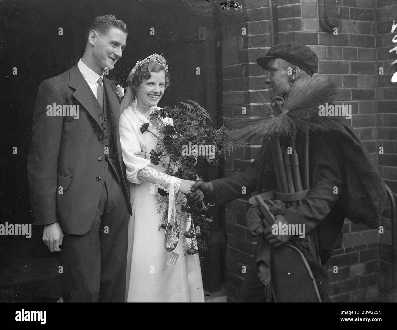 The local sweep, Mr Breezer, attended the wedding and wished good luck to the bride and groom when Miss Ivy Worden and Mr Leslie Wall free were married at St Thomas's Church, St Thomas Road Highbury. 2 October 1937. Stock Photo