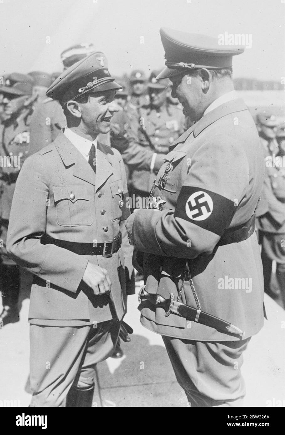 Light conversation and smiles exchanged by Dr Joseph Goebbels, Reich Propaganda Minister (left) and General Hermann Goering, Air Minister, in front of the Congress Hall at Nuremberg where it with Chancellor Hitler, they are attending the Nazi party congress, for this great occasion, General Coering has forsaken his usual resplendent garb for plain Nazi brown - with medals. 8 September 1937 Stock Photo