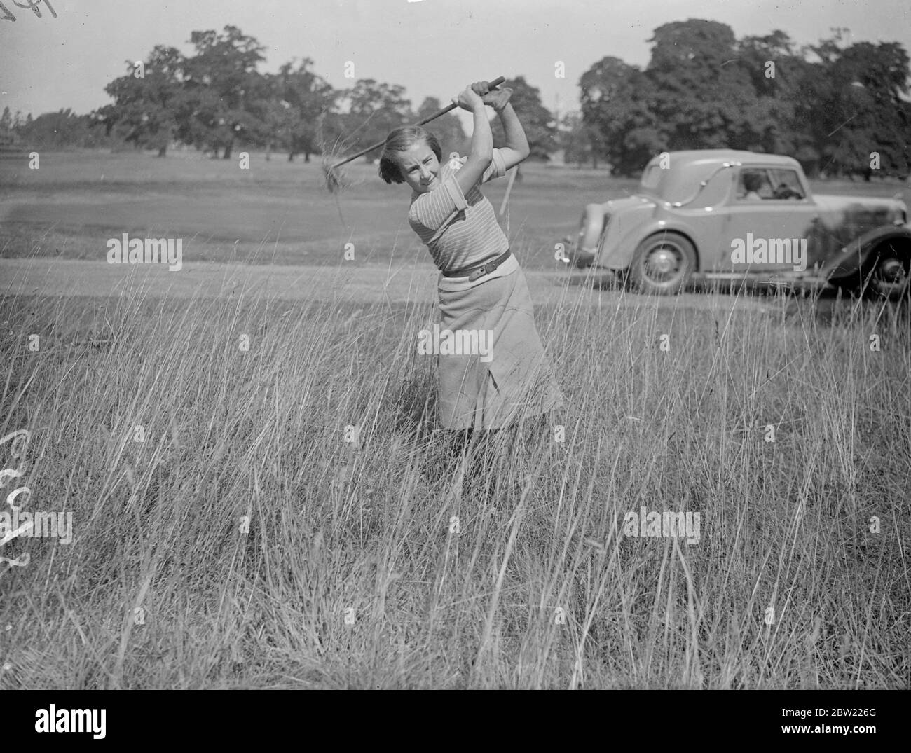 Jean McClure of the girls golfing Society, who at 14 is the youngest competitor in the girls golf Championship, playing from a bunker during practice for the tournament at Stoke Poges. The championship will be held their next Wednesday. 6 September 1937. Stock Photo