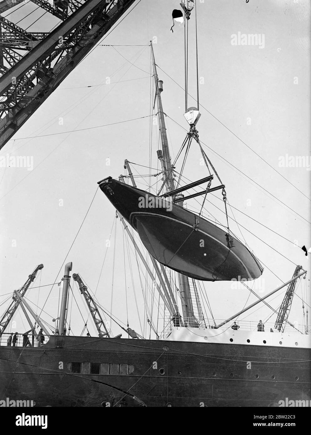 50 ton yacht hoisted onto 'Berengaria'at Southampton. The 'Elizabeth McCaw', a 50 t American ocean racing yacht was hoisted aboard the 'Berengaria'at Southampton by floating crane to be taken back to New York. The yacht was sailed from America to England to take part in ocean races here. Photo shows, the 50 t 'Elizabeth McCaw'being hoisted aboard the Berengaria at Southampton. 21 September 1937 Stock Photo