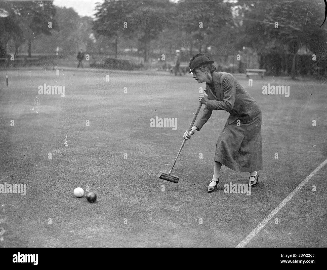 Mrs B.C Apps, the holder of the cup in play against Mr D.J.V Hamillton-Miller, at the annual croquet competition for the Presidents cup commended at the Roehampton club, London. 13 September 1937. Stock Photo