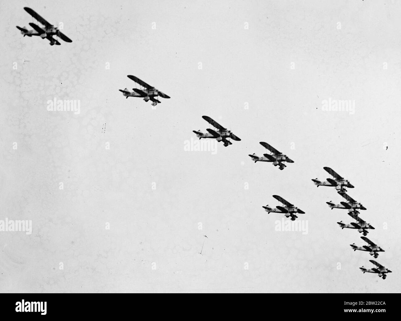 Austria reveals her secret air force. New warplanes saw over at Vienna. Vienna watched with surprised when Austria's new air force appeared in public for the first time at Aspern airfield, and dark grey monoplane bombers and swift fighters soared and dived over the heads of large crowds. The new air force is still illegal under the end of war St Germain Treaty. It has been built in the last two years. It is understood that Austria has 300 military machines, between 30 and 40, of which are bombers. Photo shows, a squadron of Austria's new warplanes Fiat CR.32, flying in formation over the Asper Stock Photo