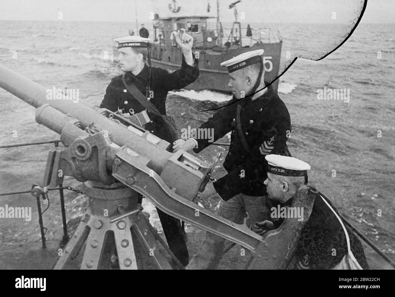 Gun crew firing during the Baltic training cruise. Russia is pushing ahead with her training the naval recruits. These youths picked from factories of the Soviet Union, are put through an intense course on Soviet warships in the Baltic. Many of them will be needed to man the battleships. With a critical international situation prevailing on her far eastern seaboard and Germany aiming the control of the Baltic. 12 September 1937 Stock Photo