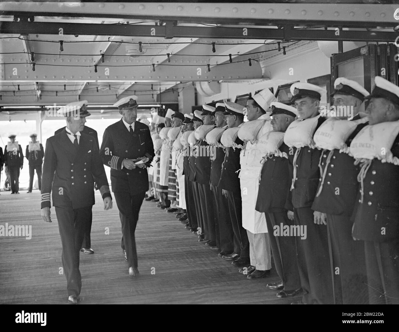 Commander Hughes, of the embarkation staff, made an official inspection of the crew and watch lifeboat in firefighting drills on the new troopship Dunera which leaves Southampton on her maiden voyage tomorrow with troops for China. 6 September 1937. Stock Photo