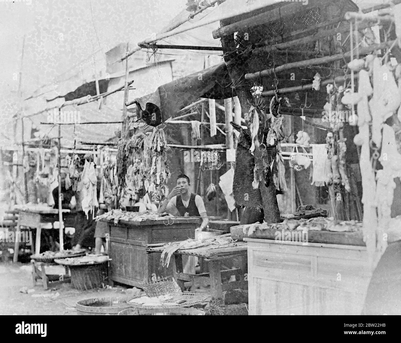 A thousand people are reported dead after a horrific dawn air raid on Canton, South China, by Japanese bombing planes. Many of the bombs fell in the densely populated poorer districts of the city. A butchers shop in a marketplace. 23 September 1937 Stock Photo
