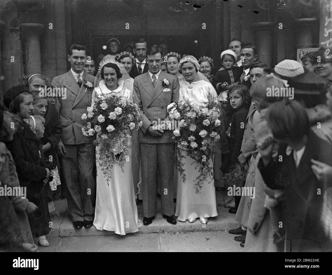 The brides and grooms leaving an unusual double wedding took place at St Matthew's Church, Southampton, when a brother and sister, Mr Francis John Craddock and miss Edith May Craddick married sister and brother, miss Flossie Annie Bartlett and Mr Frederick Ernest Bartlett. All four are members of the Mayfield novelty accordion band 11 September 1937. Stock Photo