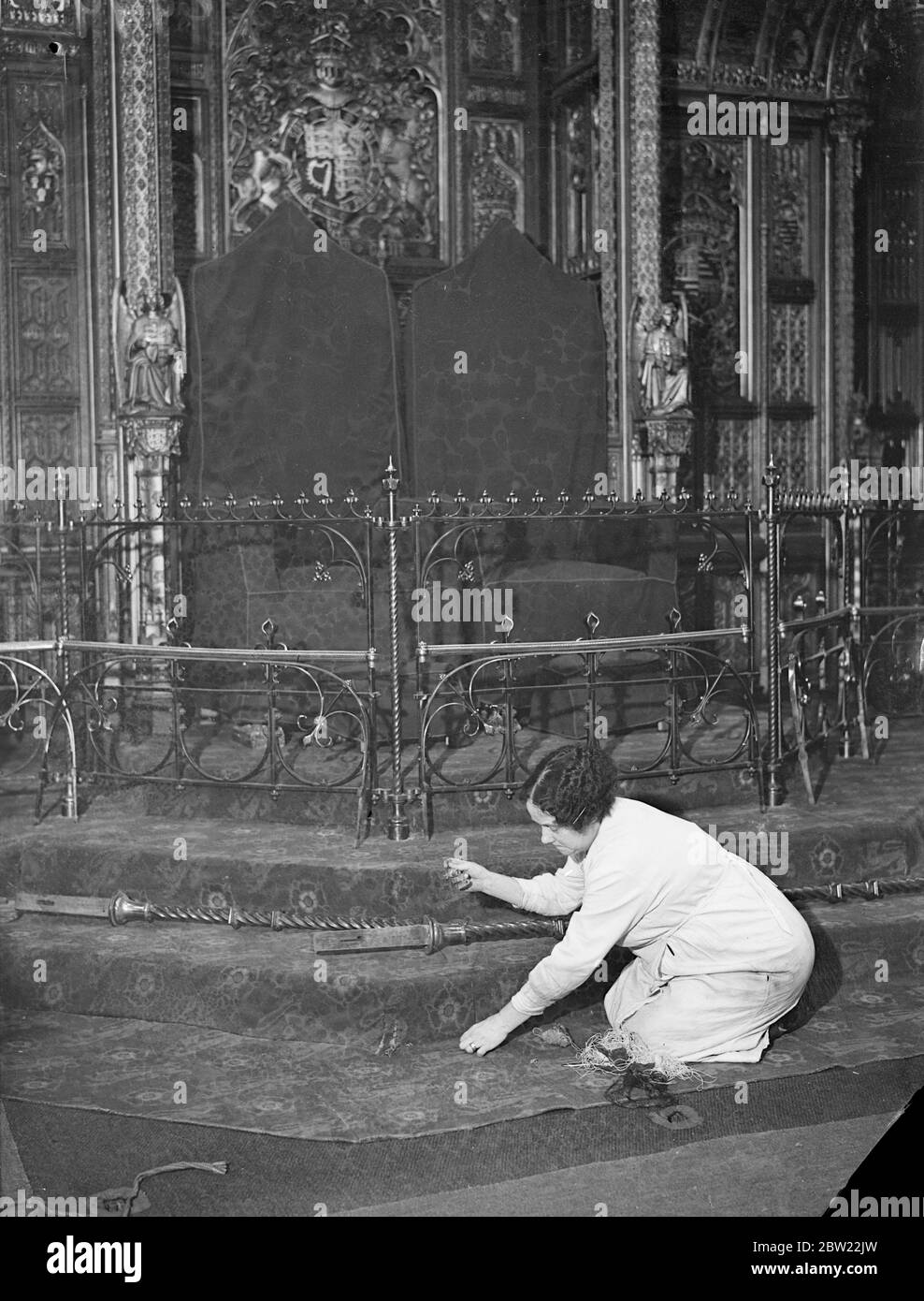 Mrs A Wheeler, who looks after all the carpets in the Houses of Parliament, stitching the carpet before the throne in which the King and Queen will sit in the House of Lords. The house is being made ready for the state opening of Parliament by the King and Queen on 26th of October when King George VI will perform the ceremony for the first time. 6 October 1937. Stock Photo