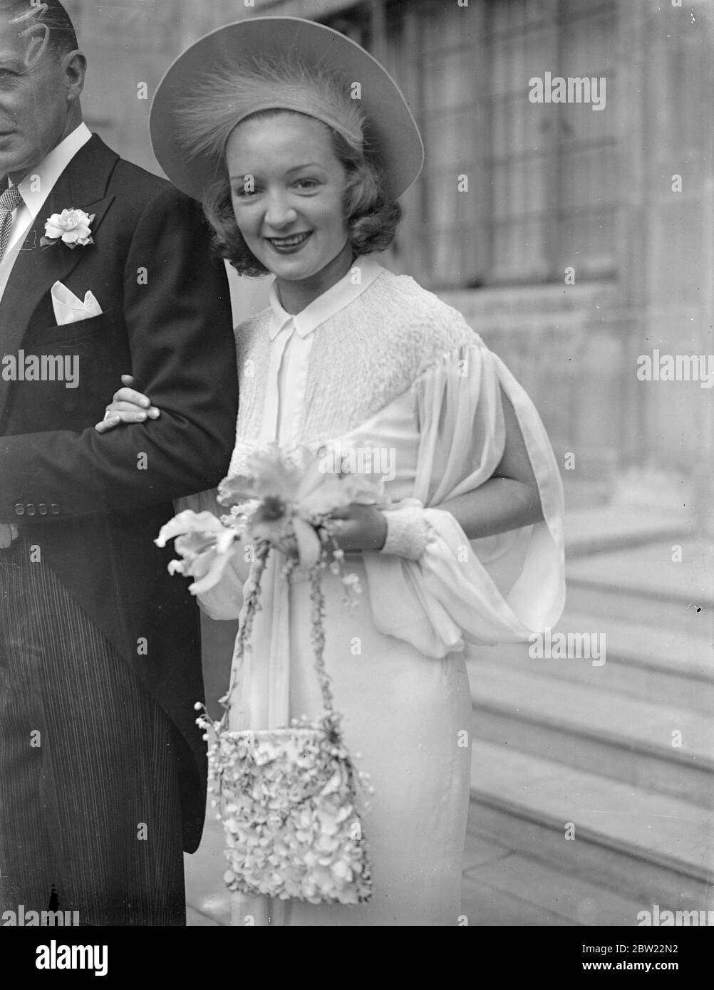 Accompanied by Clive Brooke, the film actor, Miss Florence Desmond, the actress, left her St John's Wood home for the wedding at St James Church, Spanish Place to Mr Charles, Hughesdon, the airmen. The bride set a new fashion by carrying a handbag made of hydrangeas with her initials worked in the flowers, instead of the usual bouquet. 23 September 1937 Stock Photo