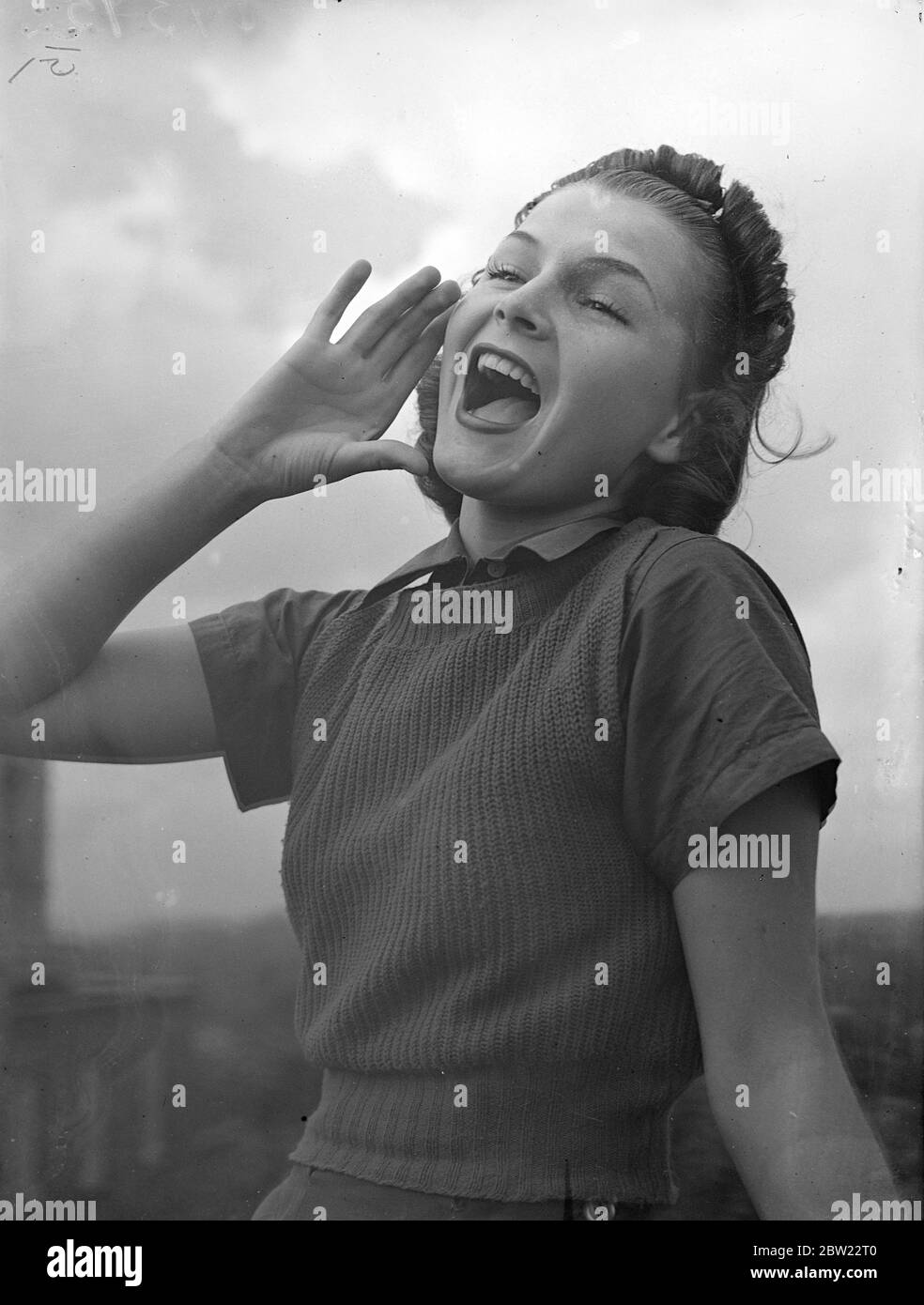 Miss Jackie Gatsley excercising her powerful vocal chords on the roof of her London Hotel. The champion hog caller has arrived in London where she is to appear in a cabaret shown. Her voice will carry more than 3 miles she learnt to use it to good purpose on her fathers mountain pig ranch in Arkansas. 16 September 1937. Stock Photo