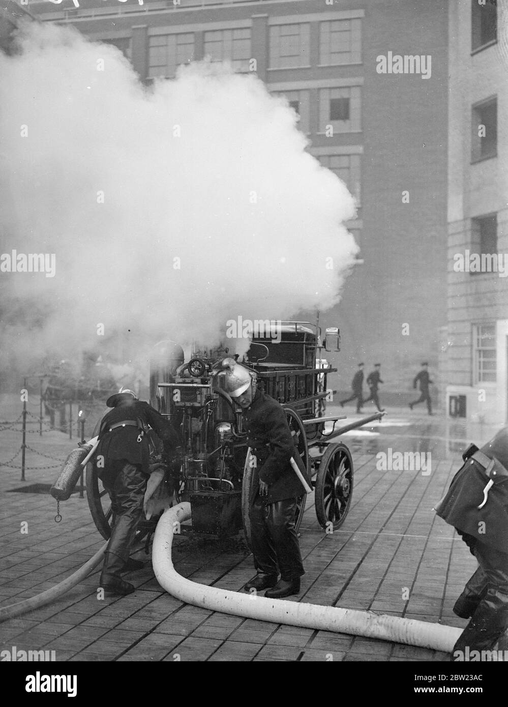 Old and new methods of firefighting demonstrated by the London Fire Brigade in a display stage before fire chief from all parts of England at the brigade headquarters in London. Fire appliances of past centuries and the most up-to-date equipment were used for the display. Firemen was an old horse engine fighting a fire during the display. 13 October 1937. Stock Photo