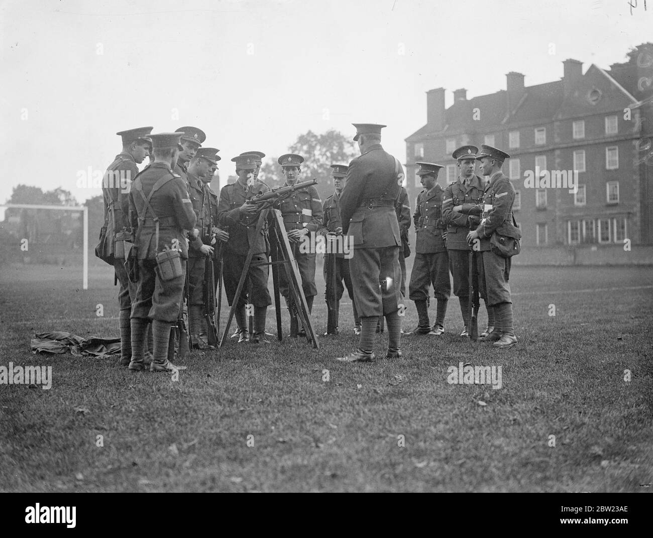 Musketry instruction for cadets of the Eton College officers training corp in the college grounds. The rifle is placed on a tripod to make it more convenient for demonstration purposes. 14 October 1937. Stock Photo