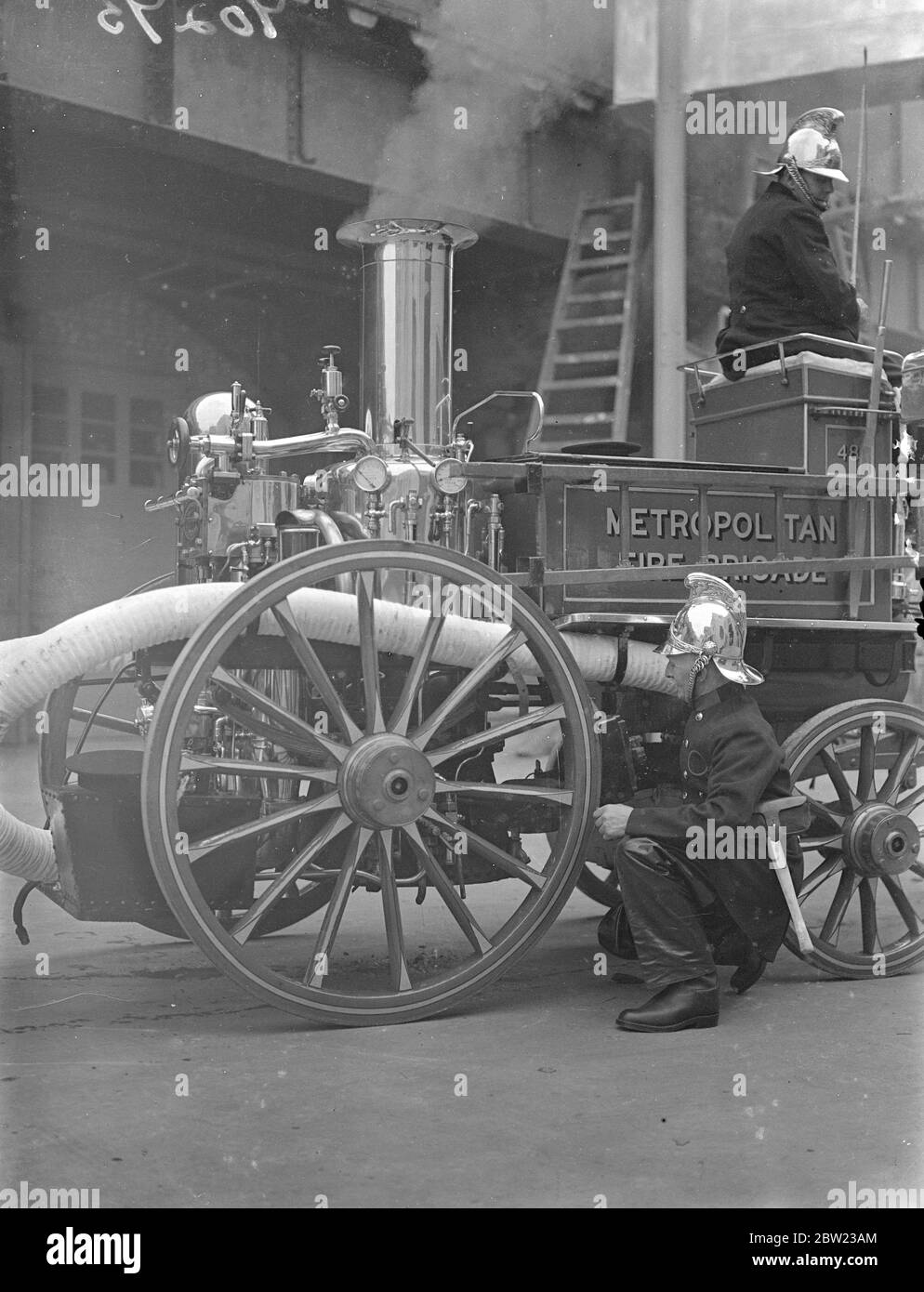 Old and new methods of firefighting demonstrated by the London Fire Brigade in a display stage before fire chief from all parts of England at the brigade headquarters in London. Fire appliances of past centuries and the most up-to-date equipment were used for the display. Firemen preparing an old steam fire engines for the display. 13 October 1937. Stock Photo