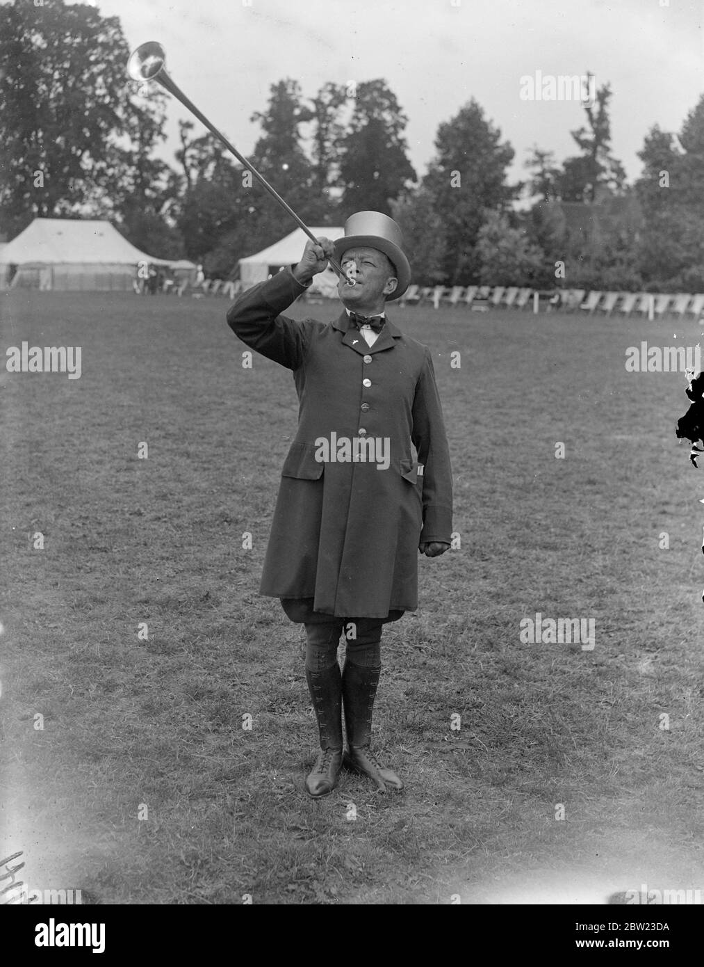 Sergeant Saunders , the post horn blower, sounding the opening of the horse show and tournament of the Metropolitan Mounted Police and their annual charity event which has opened at Imber Court , East Moseley . There are between 400 and 500 competitors from various forces in classes at the event. 7 July 1937. Stock Photo
