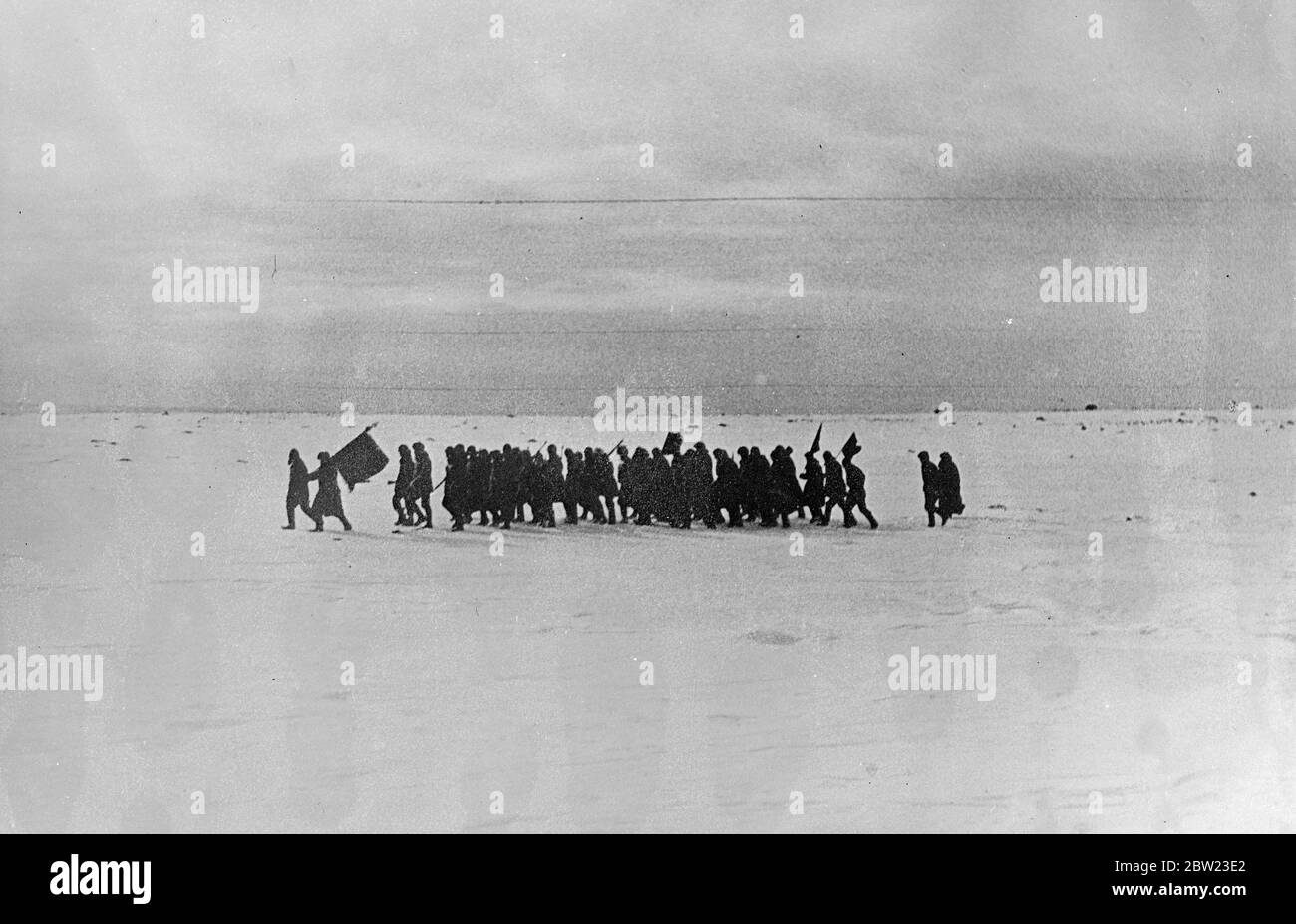 The population of the Rudolf Island settlement marching over the frozen ground to hold a meeting. Established on the island is a Soviet scientific station which, except for the North Pole is the farthest north of any in the world. 8 July 1937 Stock Photo