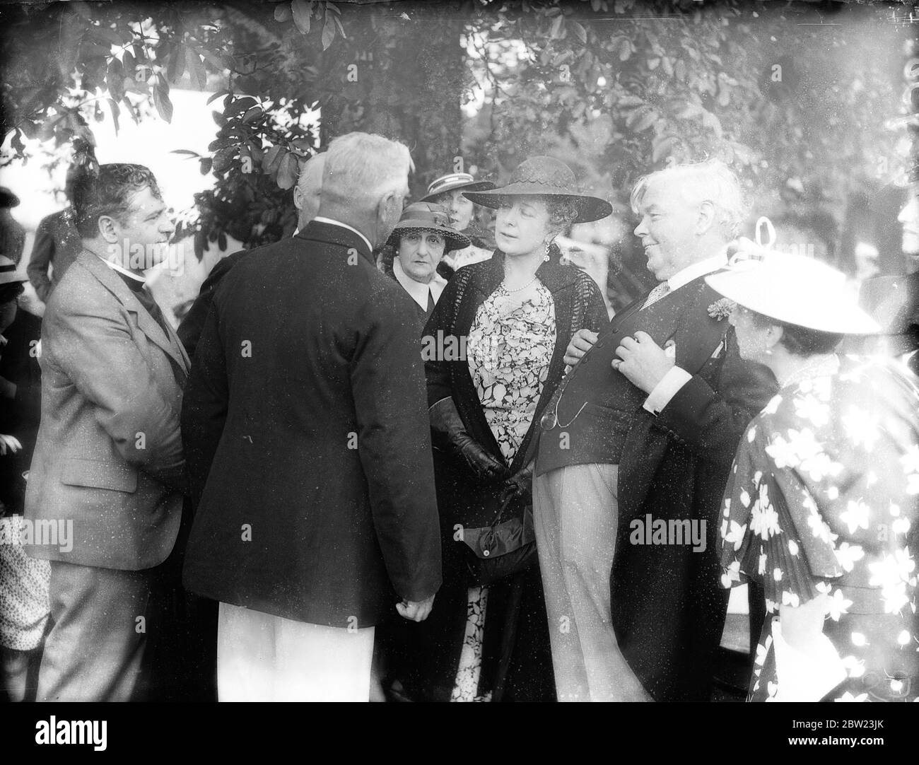 A Swan Upping party, one of the most unusual of social functions was held by Sir Patrick and Lady Hanham on Magna Carta Island. Mr Fred Turk the Kings's Swan Master gave his talk on Swan Upping. Photo shows ; Mr Fred Turk , left , talking with Mrs Neville Chamberlain , wife of the Premier and Sir Patrick and the party. 21 July 1937 Stock Photo