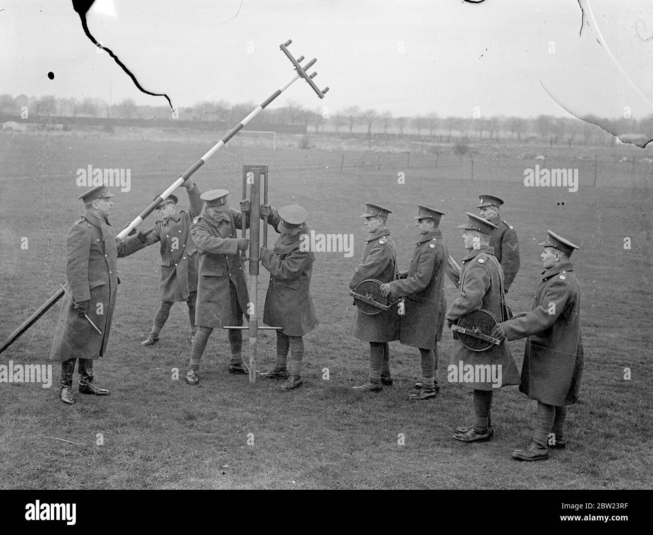 Army shows how 'communications are keeping pace with mechanisation'. Demonstrating that the vital part of 'communications'is keeping pace with the mechanisation of the army, the Royal Corps of signals , gave a display on their latest apparatus at Aldershot, Hampshire. Inter communication apparatus, radio, telephon and radio and telegraphy with mechanised cable layers were included in the demonstration. Photo shows, officers watching the Army Communication Corps men putting out radio masts for the 'for why you air line' system of communications at Aldershot. 15 February 1938 Stock Photo