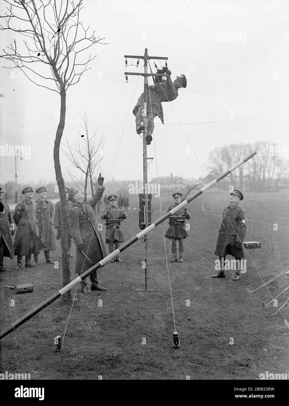 Army shows how 'communications are keeping pace with mechanisation'. Demonstrating that the vital part of 'communications'is keeping pace with the mechanisation of the army, the Royal Corps of signals , gave a display on their latest apparatus at Aldershot, Hampshire. Inter communication apparatus, radio, telephon and radio and telegraphy with mechanised cable layers were included in the demonstration. Photo shows, men of the Royal Corps of Signals erecting communication lines watched by officers at Aldershot. 15 February 1938 Stock Photo