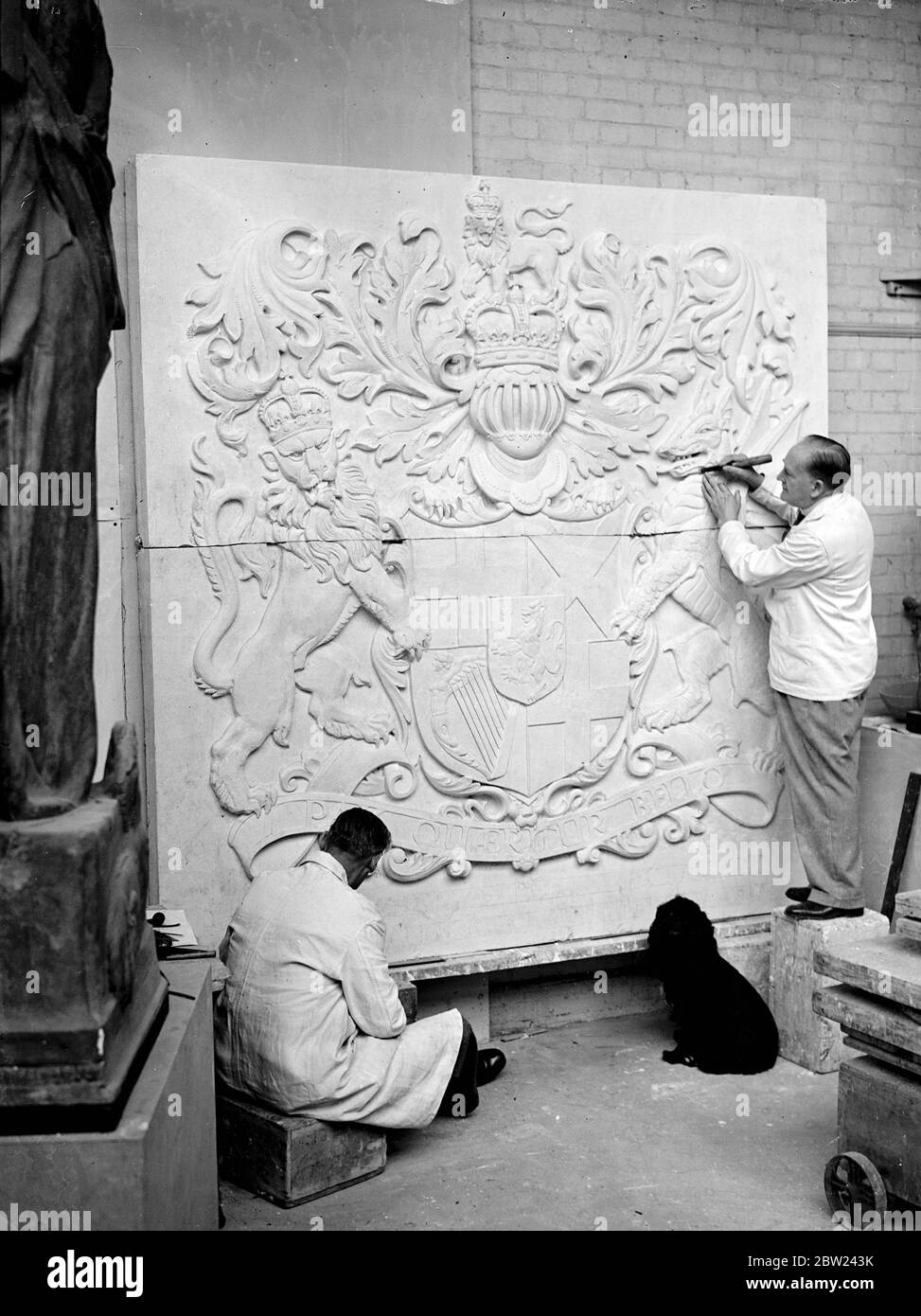 82 Heraldic shields for the British Pavilion at the New York World Fair are being made in the London studio of Mr Gilbert Bayes, the sculptor. The heraldic designs were verified by Mr Anthony Wagner, Portcullis Pursuivant at the College of Arms. Photo shows: Mr Gilbert Bayes (right) and an assistant at work on the Oliver Cromwell shield for the British Pavilion of the New York World Fair in Mr BayesLondon studio. 12 October 1938 Stock Photo
