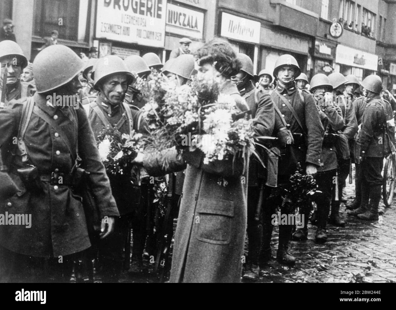 Polish forces are now in occupation of Teschen, the Polish minority district, which was ceded to Poland by Czechoslovakia in compliance with the ultimatum from Poland. The Polish demand came simultaneously with a German diplomat victory in the Sudetenland disputes. Photo shows: Polish soldiers of the army of occupation being given flowers Blanco resident. October 1938 Stock Photo
