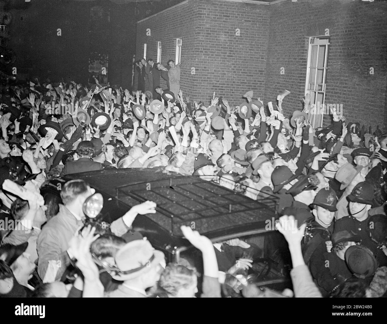 Premier welcomed by crowds packing Downing Street. Tremendous crowds which packed Downing Street gave an enthusiastic welcome to Mr Neville Chamberlain, after his return from Buckingham Palace, where he had gone immediately after landing from Munich with the 'No More War ' Pact he had signed with Hitler. Photo shows, the Forest of hands race to greet the Premier, as the crowd surged round his car in Downing Street. 30 September 1938 Stock Photo