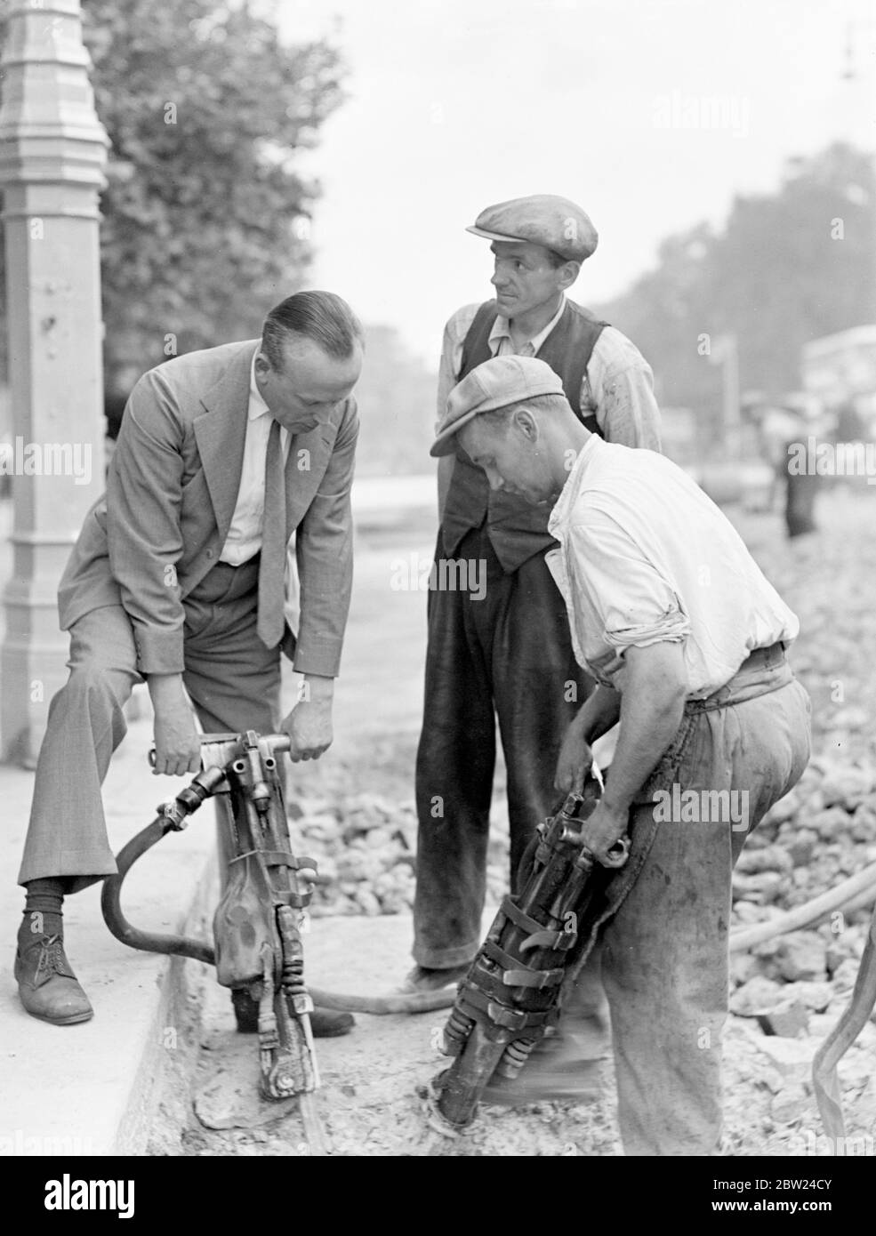 Lord Sempill, the air man, was walking down Piccadilly, when he indulged in a favourite pastime of Londoners, watching men at work in a hole in the road. He went further than that, however, and spend half an hour operating a pneumatic drill. Photo shows: Lord Sempill using the pneumatic drill in Piccadilly. 2 September 1938 Stock Photo