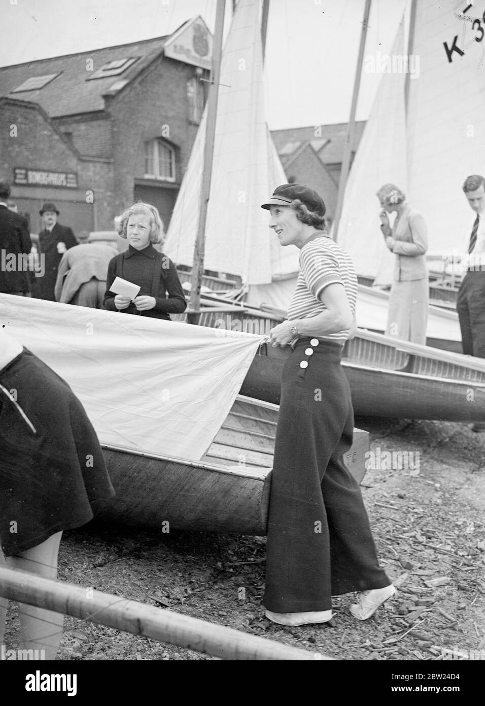 Mrs P Reilly, in nautical costume, including long trousers, striped jersey and peaked cap, preparing the yacht Duet for the Ranelagh Trophy Race on the Thames at Putney. 11 September 1938 Stock Photo