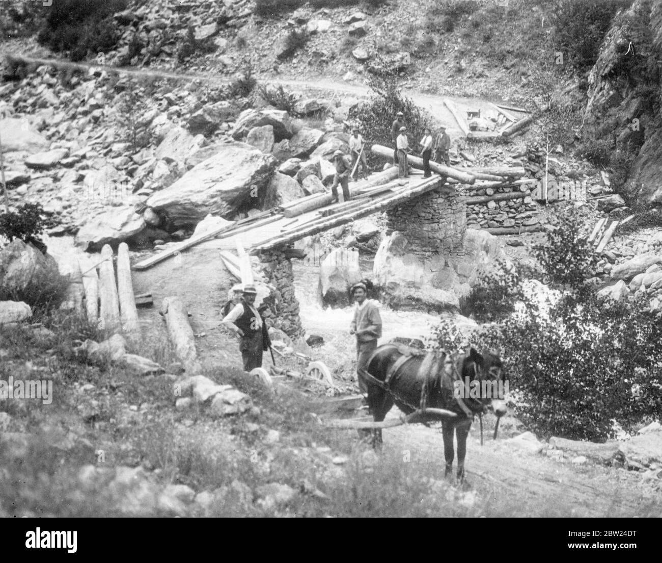 Workmen repairing the frontier bridge which links Italy and France near Isola, the French village in Italian territory. The population of the village has orders to quit from the Italian authorities on the grounds that the land is required for Italian defence works. The French colony has been granted a short period of grace and is trying to get in the harvest before leaving it. 10 September 1938 Stock Photo