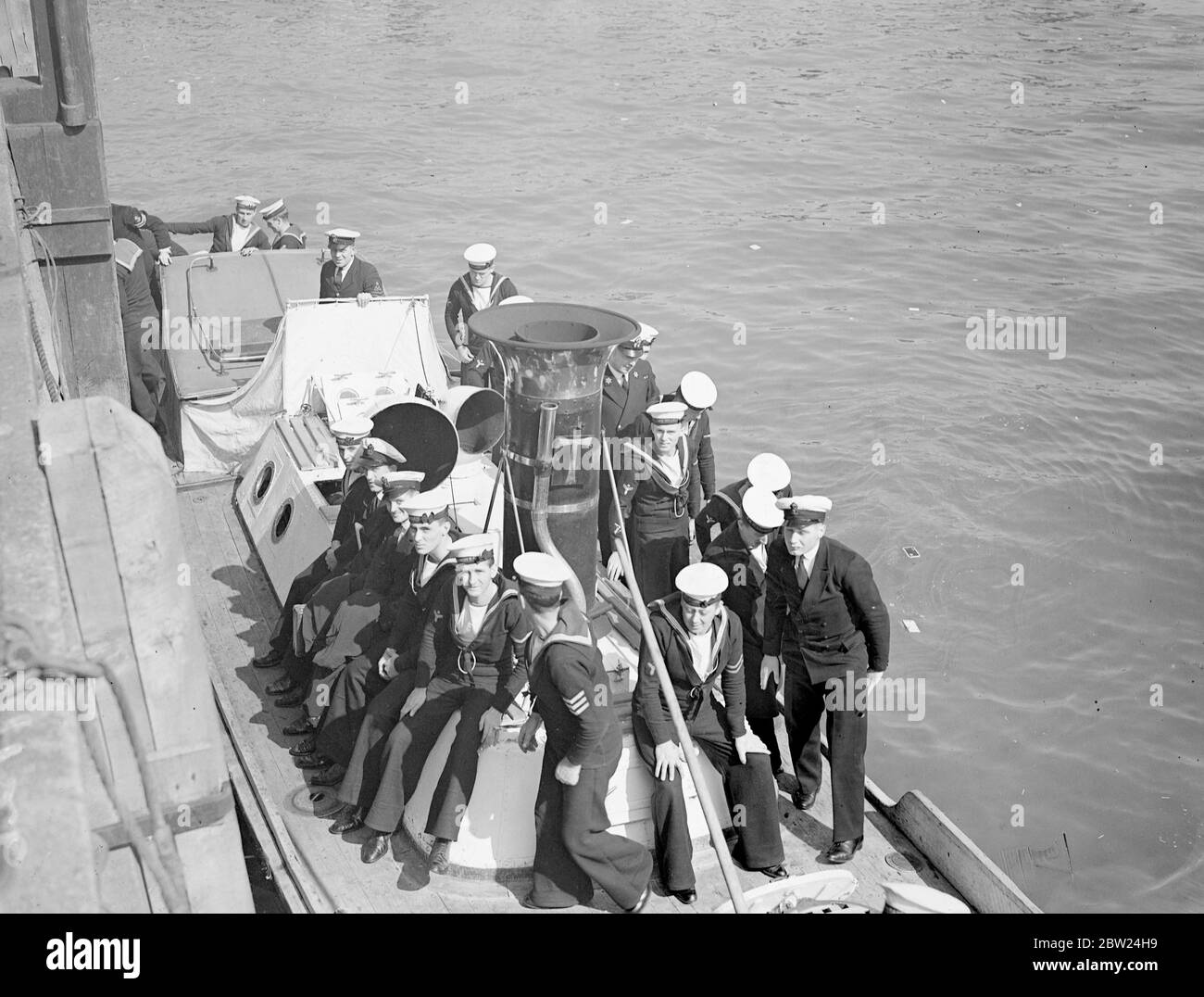 Swift measures have been taken by the British Admiralty owing to the Sudeten-German-Czech crisis which is expected to reach a climax this weekend. Although most of the home fleet is concentrated at Invergordon, submarine flotillas are standing by Portland and the First Minesweeping Flotilla is being brought up to full complement while four minelaying destroyers are to be placed in full commission from reserve. Photo shows: Sailors coming ashore from the depot ship HMS Titania. 11 September 1938 Stock Photo