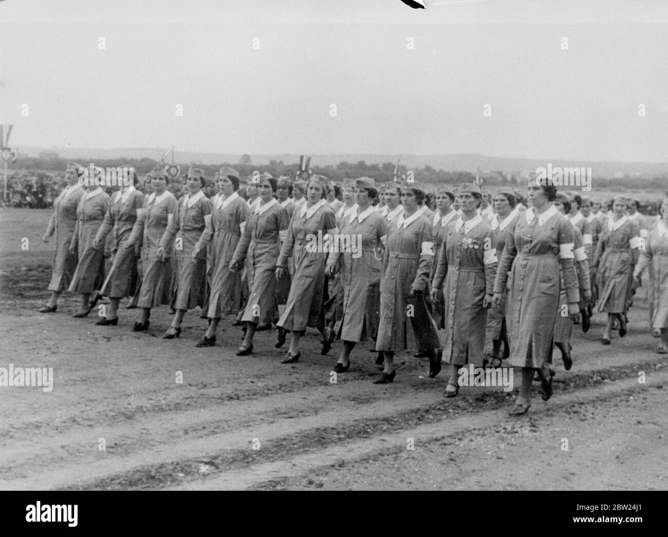 Women auxiliaries are in the big military review at Bagnitza camp near Belgrade, arranged as part of the collaboration on the 50th birthday of the boy king, Peter II. Prince Paul, the chief Regent, and the Yugoslav cabinet attended. Photo shows: Women auxiliaries marching past in the review 8 September 1938 Stock Photo