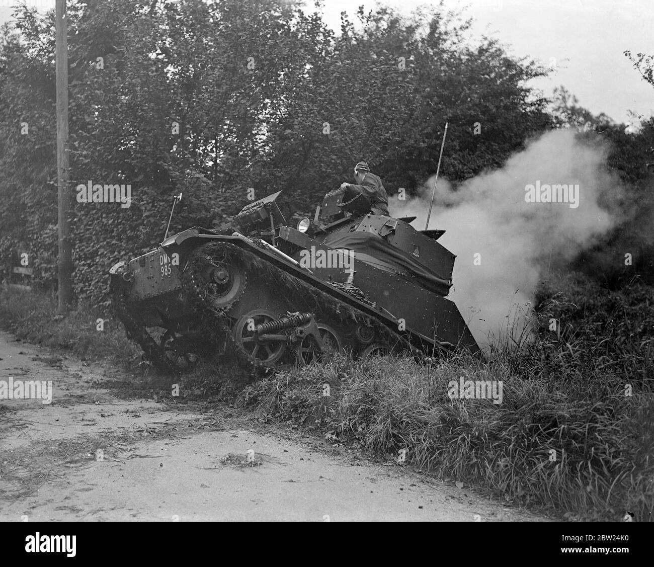 A tank climbs out in the Hampshire 'war'. The Squadron leader tank of the 4th Hussers (Radland) in a Light, Mk VI climbing out of a ditch when coming to grips with Whiteland forces near Stockbridge during the big manoeuvres of the 1st and 2nd Division in Hampshire. 29 August 1938 Stock Photo