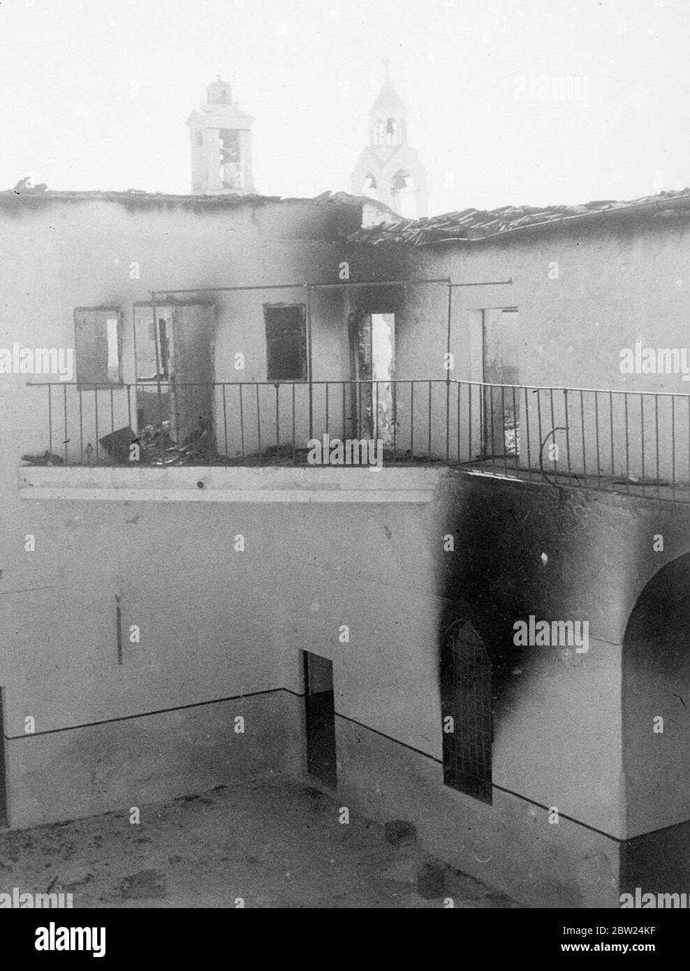 The most daring exploit so far of the Arab rebels in Palestine was the invasion of Bethlehem. The chief object of attack was the post office in police station, both have been gutted during the rebels occupation of the city. The police station was situate where Christ was born. Photo shows: Part of the burnout police station building. The station was on the ground floor and the law court on the first floor. In the background are seeing the two spires which surmount the Church of the Nativity. 19 September 1938 Stock Photo