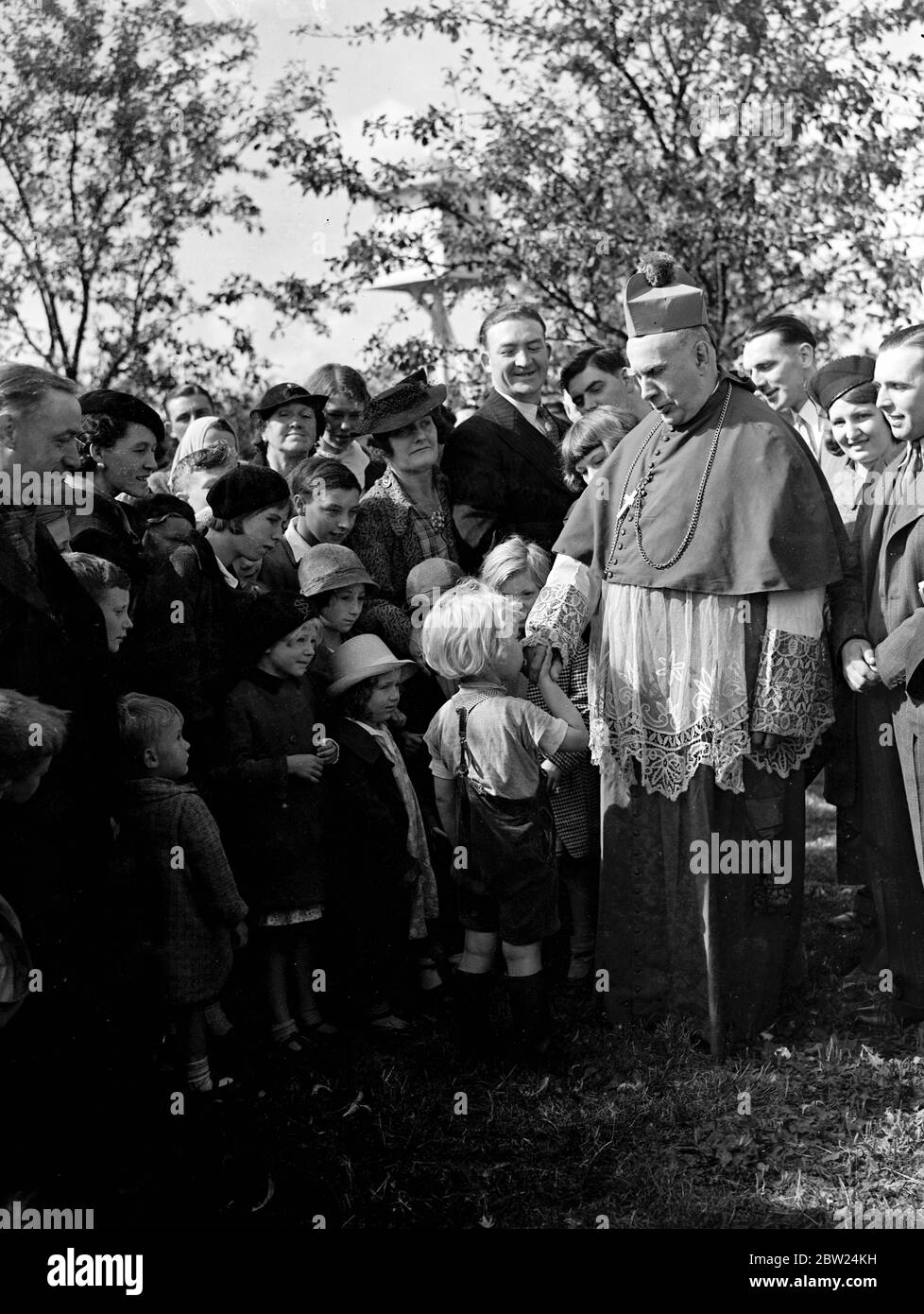 Kissing the Archbishop's ring in the hop gardens. The Archbishop Bishop of Southwark, the Rt Rev P E Amigo, made his annual visit to the Kent hop gardens today (Sunday) and celebrated a special Hop Pickers Mass at Horsmonden. Photo shows, a little girl kissing the ring of the Archbishop Bishop at Horsmonden. 4 September 1938 Stock Photo