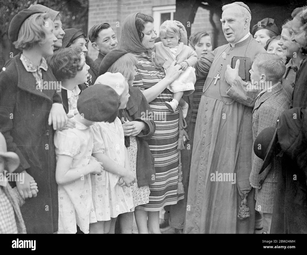 Kissing the Archbishop's ring in the hop gardens. The Archbishop Bishop of Southwark, the Rt Rev P E Amigo, made his annual visit to the Kent hop gardens today (Sunday) and celebrated a special Hop Pickers Mass at Horsmonden. Photo shows, the Archbishop Bishop patting the baby's hand after the mass.. 4 September 1938 Stock Photo