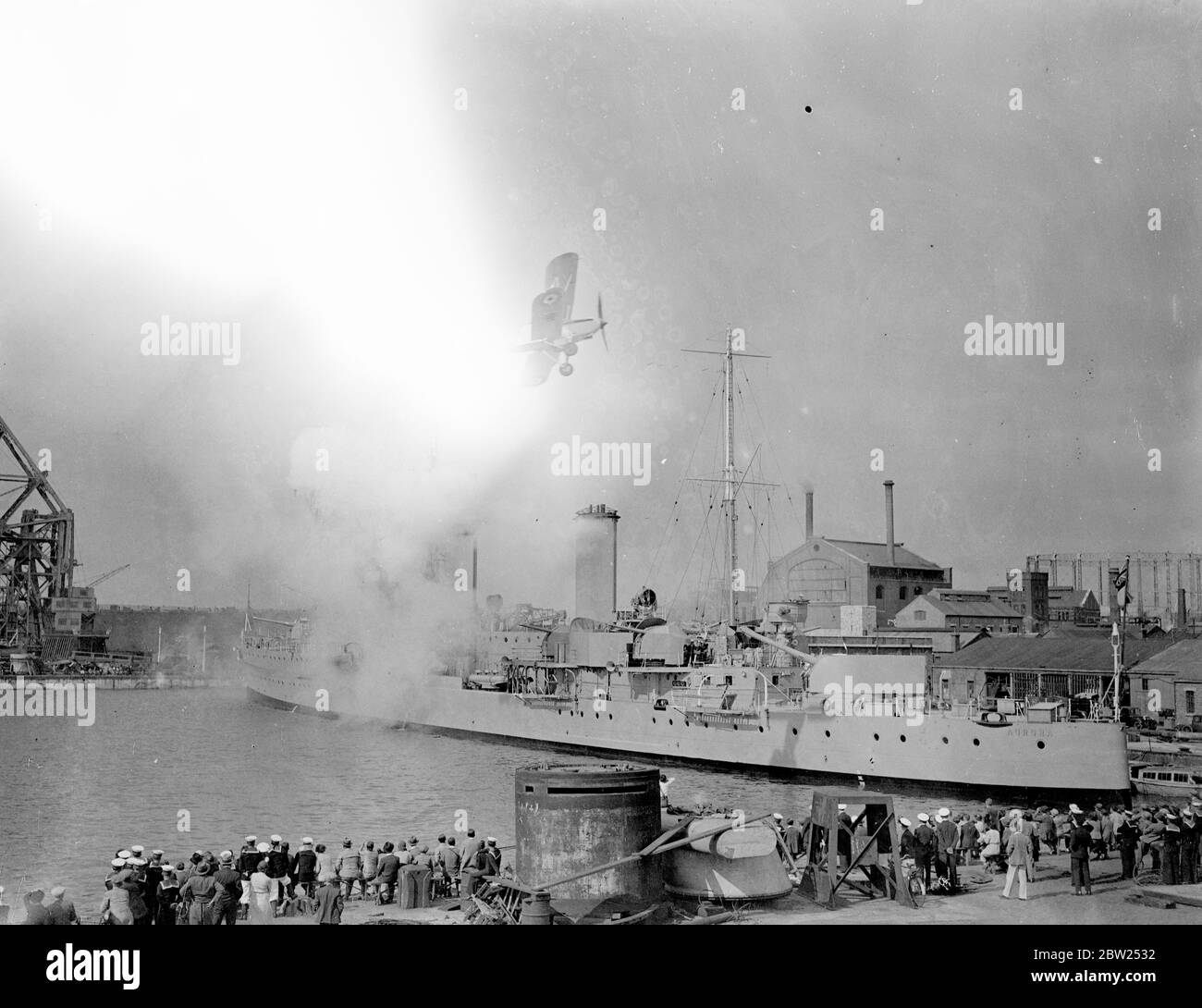 Plane attacks warship in Portsmouth Navy week display. A plane of the Fleet Air Arm flying low over the dockyard as it attacks the warship 'HMS Aurora'during the first day of the Navy week at Portsmouth. Large crowds were in attendance. 31 July 1938 Stock Photo