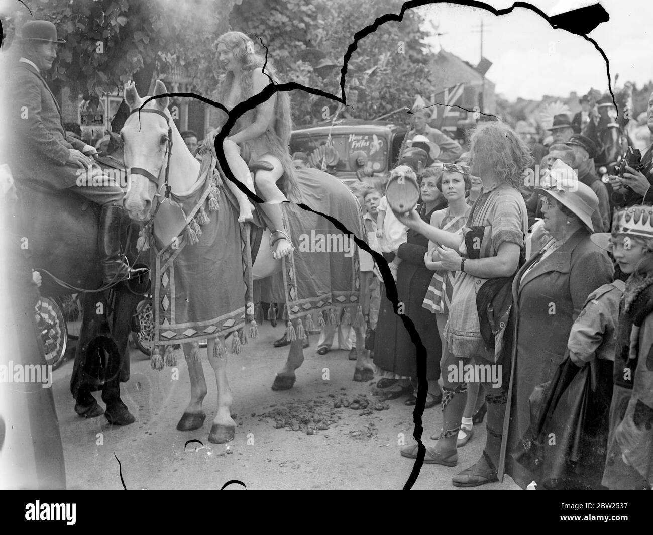 12 year old girl as 'Lady Godiva' in Teddington Carnival. Mirabelle Muller, the 13 year old schoolgirl, rode on a white horse as 'Lady Godiva' in the Carnival Fate procession at Teddington, middlesex. Mirabelle was asked to leave her convent school after she had been chosen as Godiva. Phpto shows, a general view of the Carnival procession, showing Mirabelle Muller as Lady Godiva.. 6 July 1938 Stock Photo