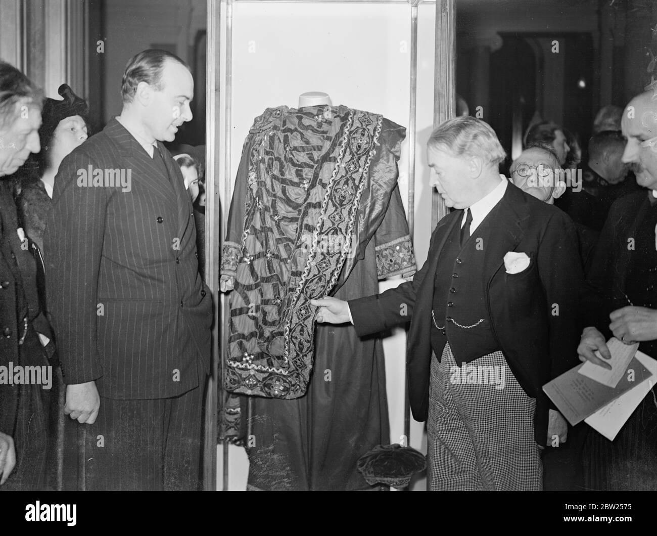 Exhibition of Irving relics opened by Sir John Martin Harvey in London. Actors grandson present. Sir John Martin Harvey, the actor, opened the Centenary Exhibition of relics of Sir Henry Irving at the London Museum in St James's, London.. The exhibition commemorates the centenary of the birth of one of the greatest tragedians, the stage has known. Photo shows, Sir John Martin Harvey and Mr Laurence Irving , a grandson of the actor, ispecting the costume Sir Henry Irving was wearing in 'Becket' the night he died. After the performances at he Theatre Royal, Bradford in 1908, he collaped and died Stock Photo