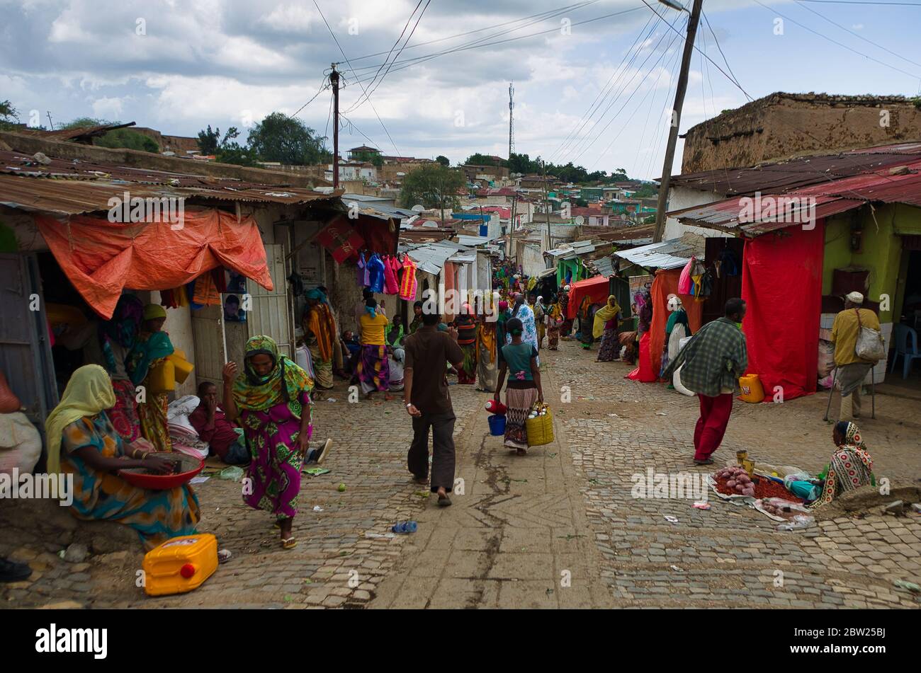 Women in colorful traditional African costumes crouching at a vegetable