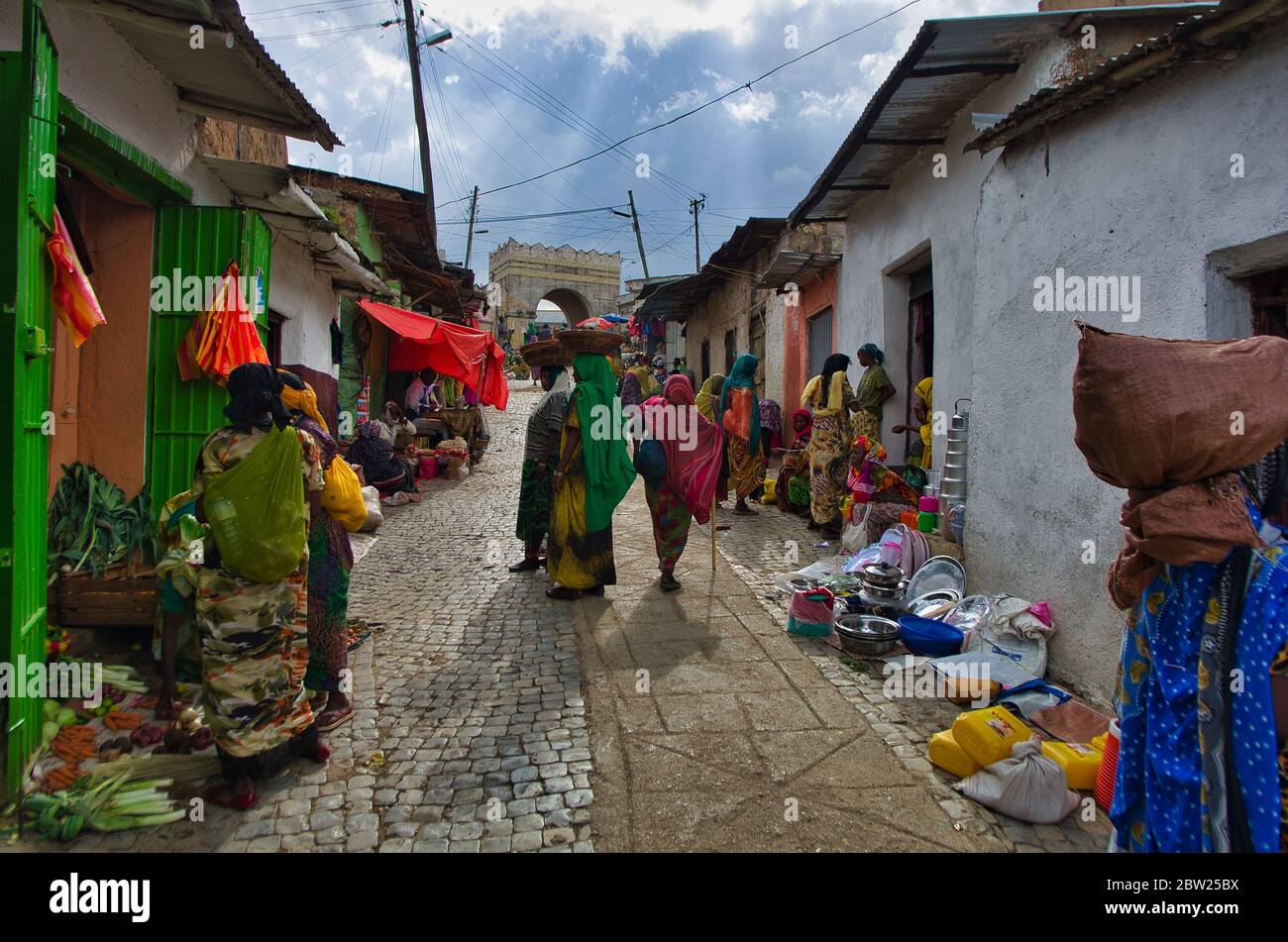 Women in traditional costumes with baskets on their heads at the colourful street market in the city of Harar. Harar, Ethiopia. 24 August 2014 Stock Photo