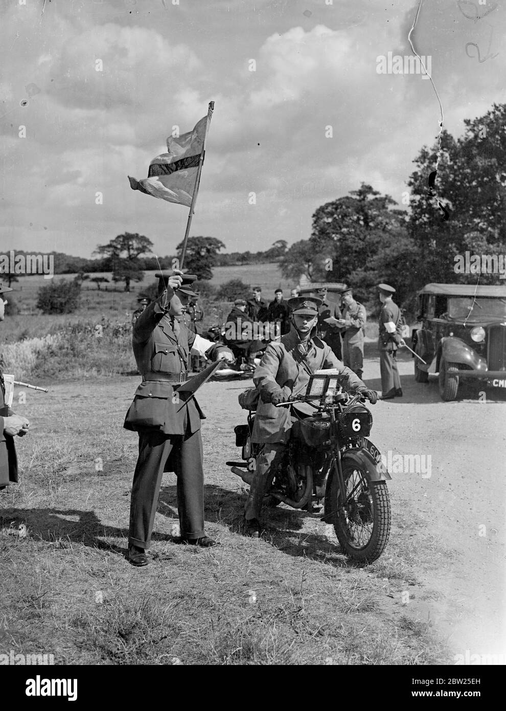 First army motor cycle reliability trials starts at Wimbledon. Army motor cyclists of the Eastern Command took part in the first of the Army Reliability Trials recently sanctioned by the War Office, which started from Wimbledon Common, London, and continued over a 50 miles course. Photo shows, flagging away a competitor at the start.. 30 June 1938 Stock Photo