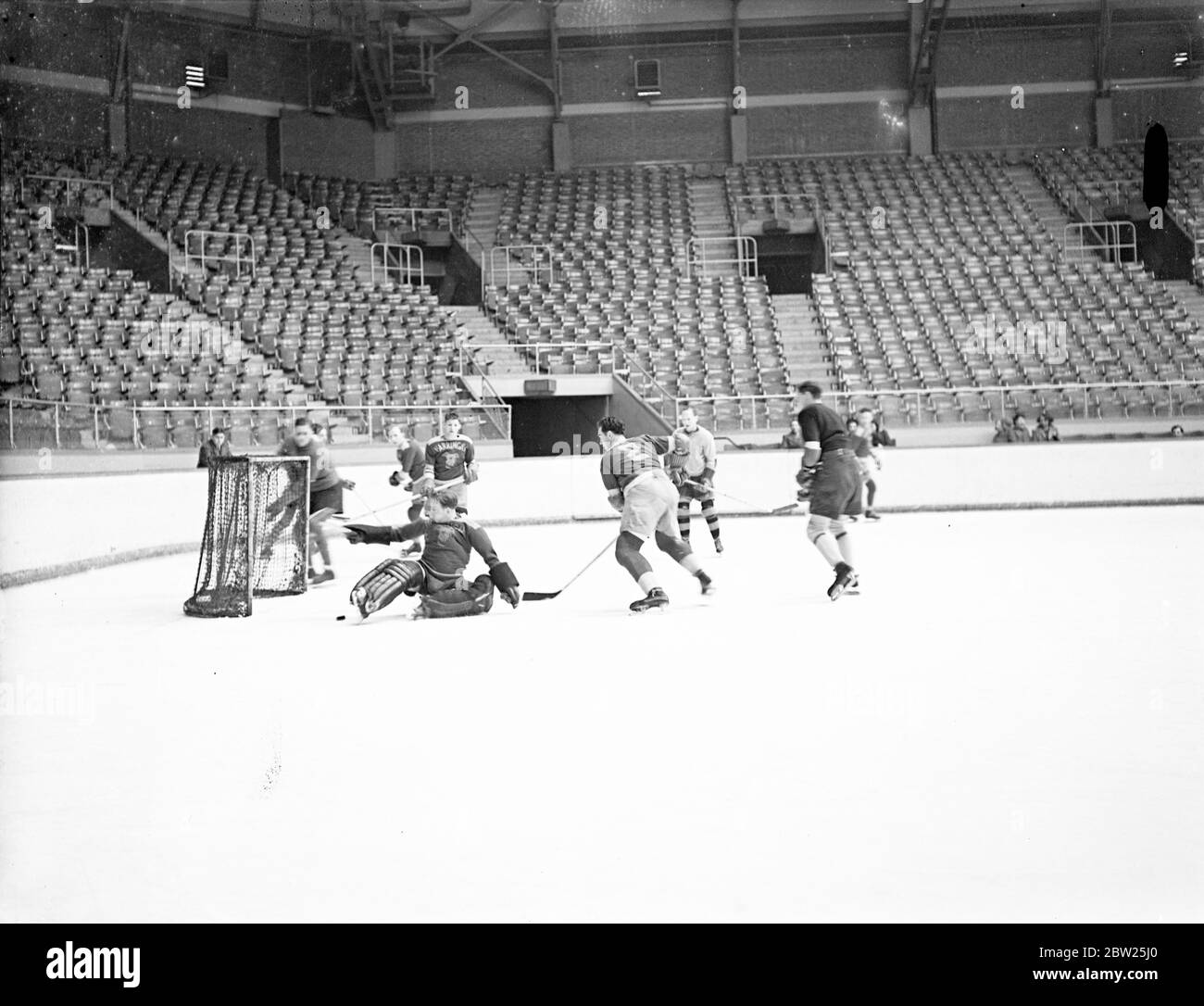 England's ice hockey team for world Championships have trial match at Harringay. The English ice hockey team which is to compete in the world Championships at Prague towards the end of next month, had a trial match at Harringay arena with the Harringay Greyhounds who are noted for their strong defence lines. Photo shows, Jimmy Foster, who has been selected as England goal minder for the third successive year, on the ice as he made a save at the trial match. On this occasion, Foster was flying for Greyhounds in order to be thoroughly tested by his colleagues. 31 January 1938 Stock Photo