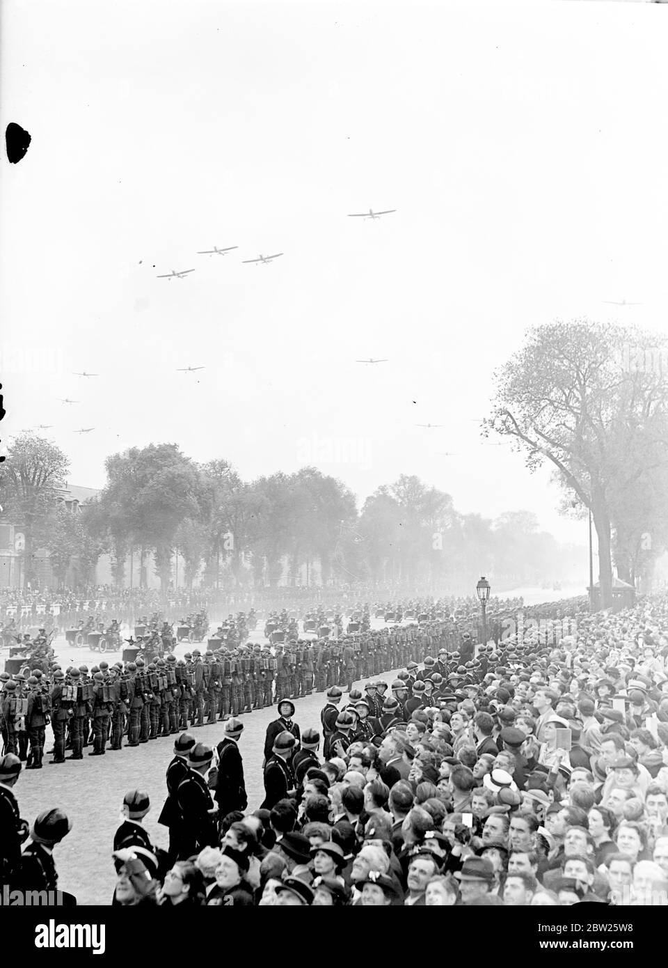 King sees might of French Army on parade at Versailles. The King, accompanied by President Lebrun, reviewed over 40,000 men of the French Army, including cavalry, mechanised and colonial divisions, at a parade in his honour at Versailles, Paris. During a review 600 planes flew overhead. Photo shows, a general view of the parade with aerolanes flying overhead. 21 July 1938 Stock Photo