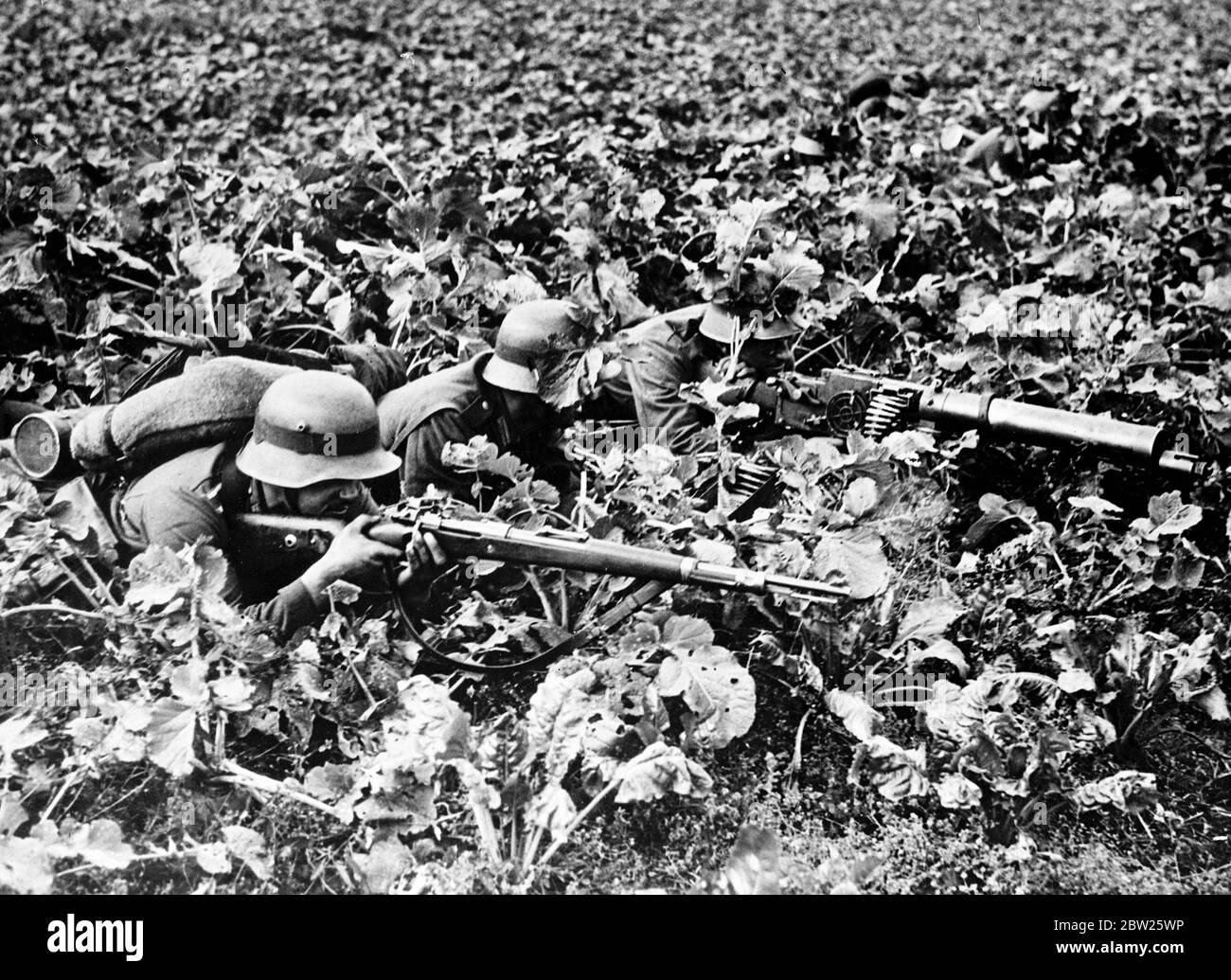 Germany in a state of 'war' as big manoeuvres start, 750,000 men called to colours. Manoeuvres on a vast scale that they have caused alarm in many parts of Europe has started in Germany and will last 10 weeks. Among the dramatic manoeuvres taken by the authorities have been the calling to colours of 750,000 reservists at the requisitioning of food, horses and motor vehicles. The areas where the exercise are taking place will be virtually under martial law during the period of the manoeuvres. Photo shows, machine gun nest in a field during the German manoeuvres. 15 August 1938 Stock Photo