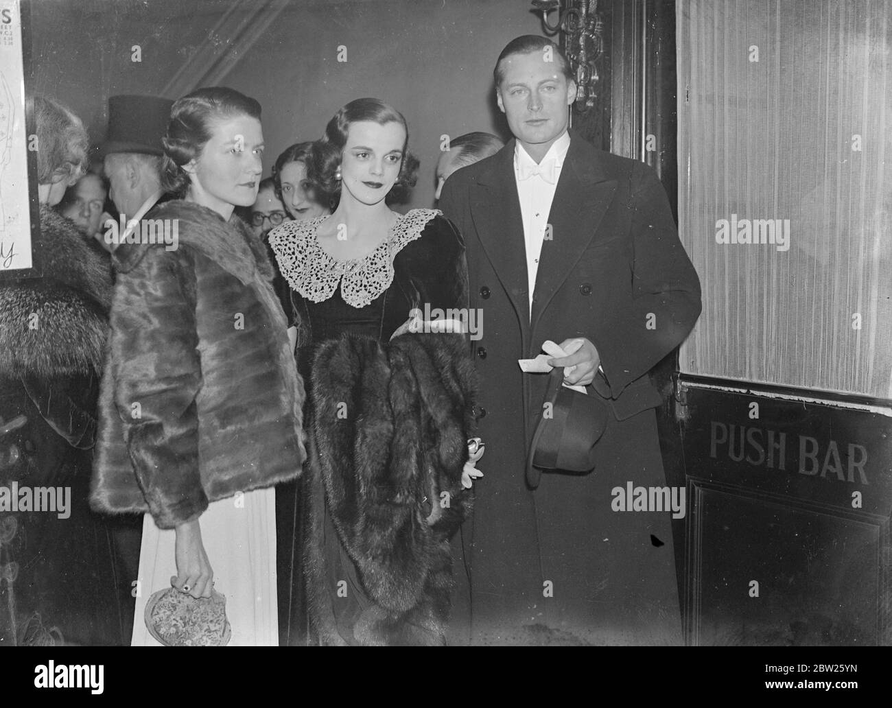 Britain's first 'First Night' hostess receives royalty at London theatre. Mr Jeanne Steurton, Britain's first 'first night' hostess, took up her duties at the Ambassadors Theatre, London, for the first night of 'Nuts in May', the new comedy. Miss Steurton's duties consist of welcoming celebrities and ensuring the comfort of members of the audience. Among the play goers , she received on the first night of 'Nuts in May' were Prince Frederich of Prussia and Princess Helena Victoria. 4 February 1938 Stock Photo