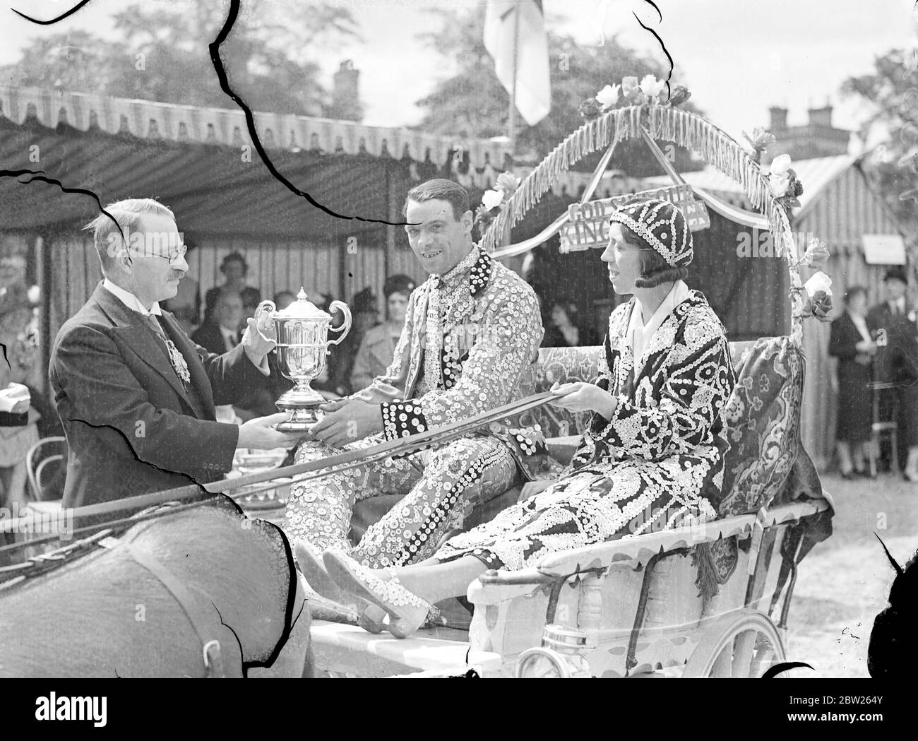 Lord Mayor presents Cup to owners of 'best donkey in costers' show. Dressed in all their finery, costere exhibited their animals at the annual Costers and Street Traders Donkey and Pony Show on Kensington Palace Field, London. The Lord Mayor presented the prizes. Photo shows, The Lord Mayor, Sir Harry Twyford, presenting the Queen Alexandra Cup to Mr and Mrs Tom Newman whose donkey Mike was judged the best in the show. 4 July 1938 Stock Photo