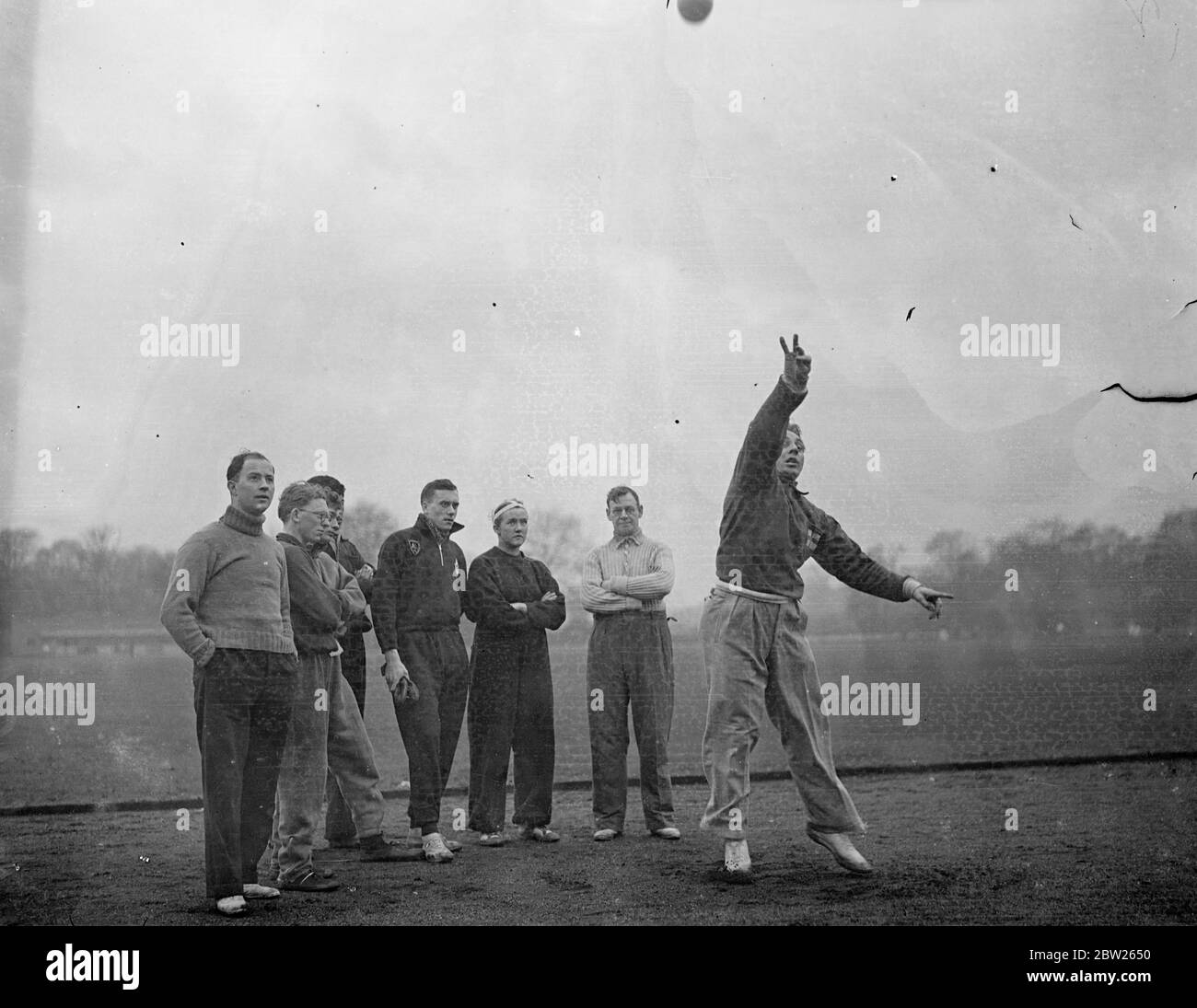 Finnish Olympic champion gives public demonstration to London athletes. Invited by the Amateur Athletics Association to tour Britain and gives displays, Armee Vaalate, the Finnish Olympic champion gave his first public demonstration in Battersea Park, London, today (Sunday). He has already given lectures and displays to the army and police force. Photo shows, Vaalste demonstrating putting the shot to a group of athletes in Battersea Park. 30 January 1938 Stock Photo