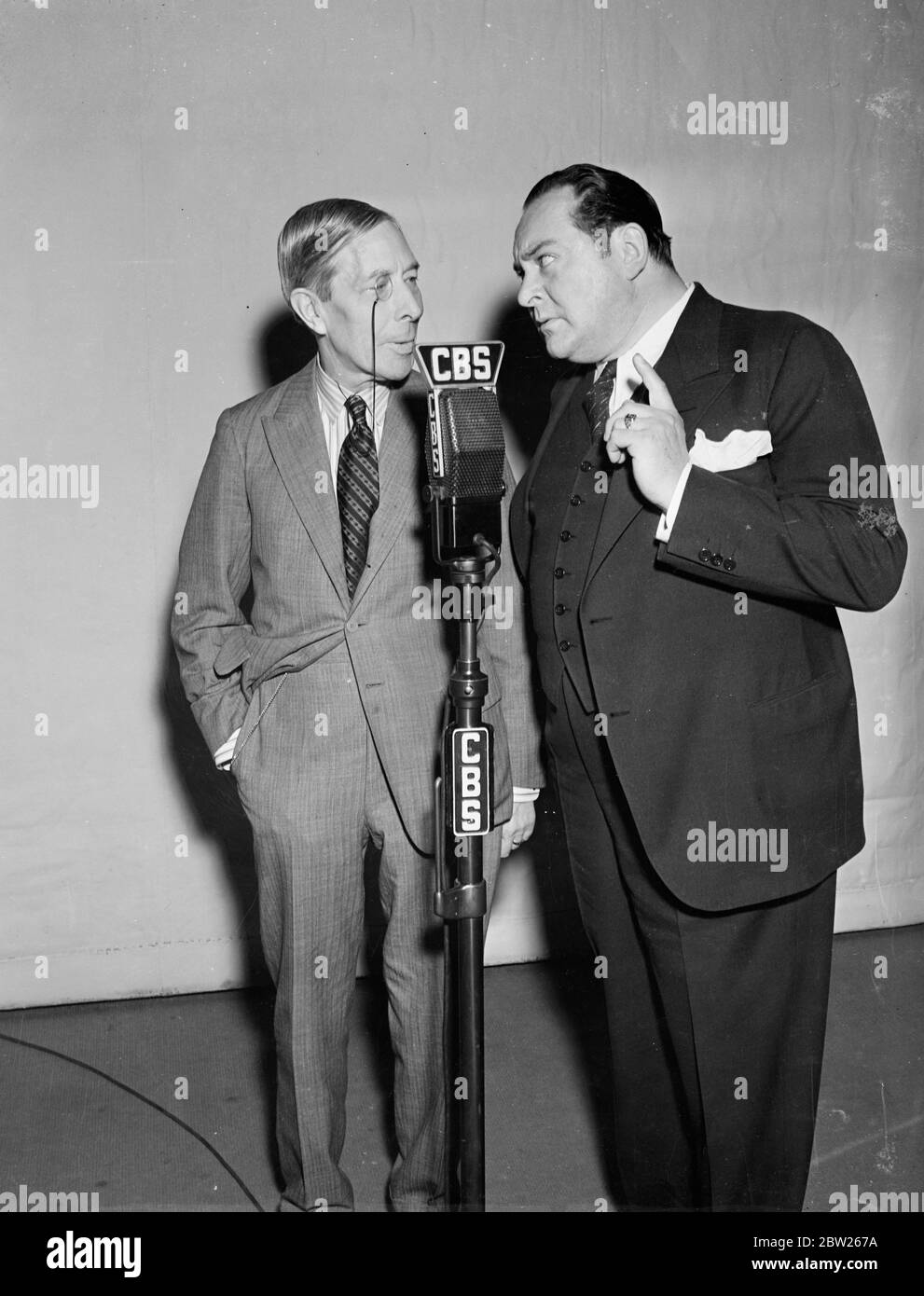 George Arliss broadcast with Edward Arnold. Radio version of 'Disraeli'. Mr George Arliss, the British film and stage actor, made one of his rare radio 'appearances' when he broadcast is great success 'Disraeli' from the Hollywood studio of the Columbia broadcasting system. The radio version was produced by Edward Arnold, the film actor. Photo shows, George Arliss (left) with Edward Arnold before the microphone in Hollywood. 29 January 1938 Stock Photo