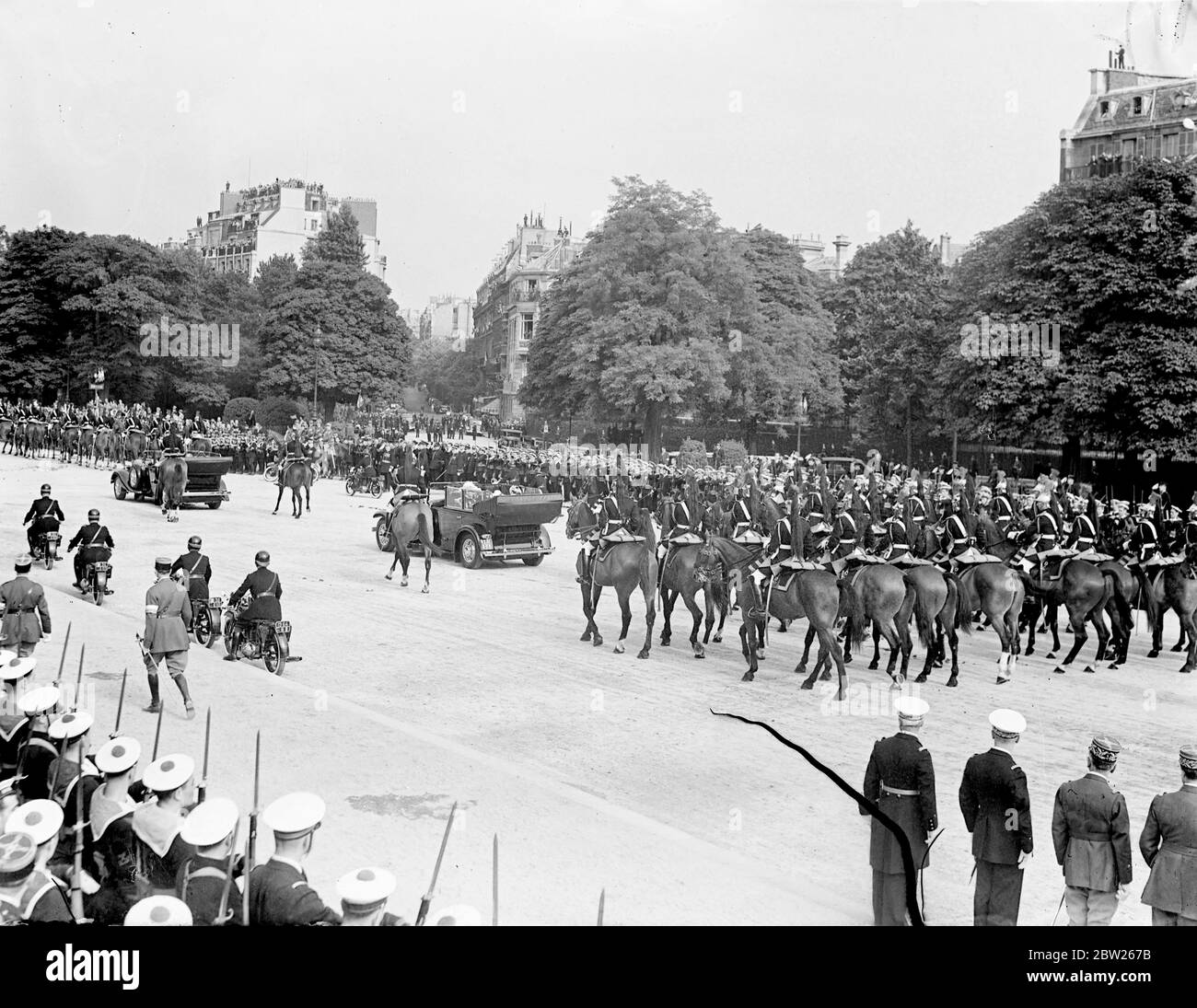King and Queen receive tumultuous welcome in Paris. Welcomed by 1 million cheering people and the thunder of 101 gun salute, the King and Queen arrived at the Gare Bois de Boulogne on their State visit to Paris. Accompanied by President Lebrun of France and Mme Lebrun , they made the 4 mile drive through decorated streets lined with troops and crowds to the Qui d' Orsay Palace , where they are staying. Photo shows, the Queen and Mme Lebrun , driving from Bois de Boulogne Station to the Quai d'Orsay. 19 July 1938 Stock Photo