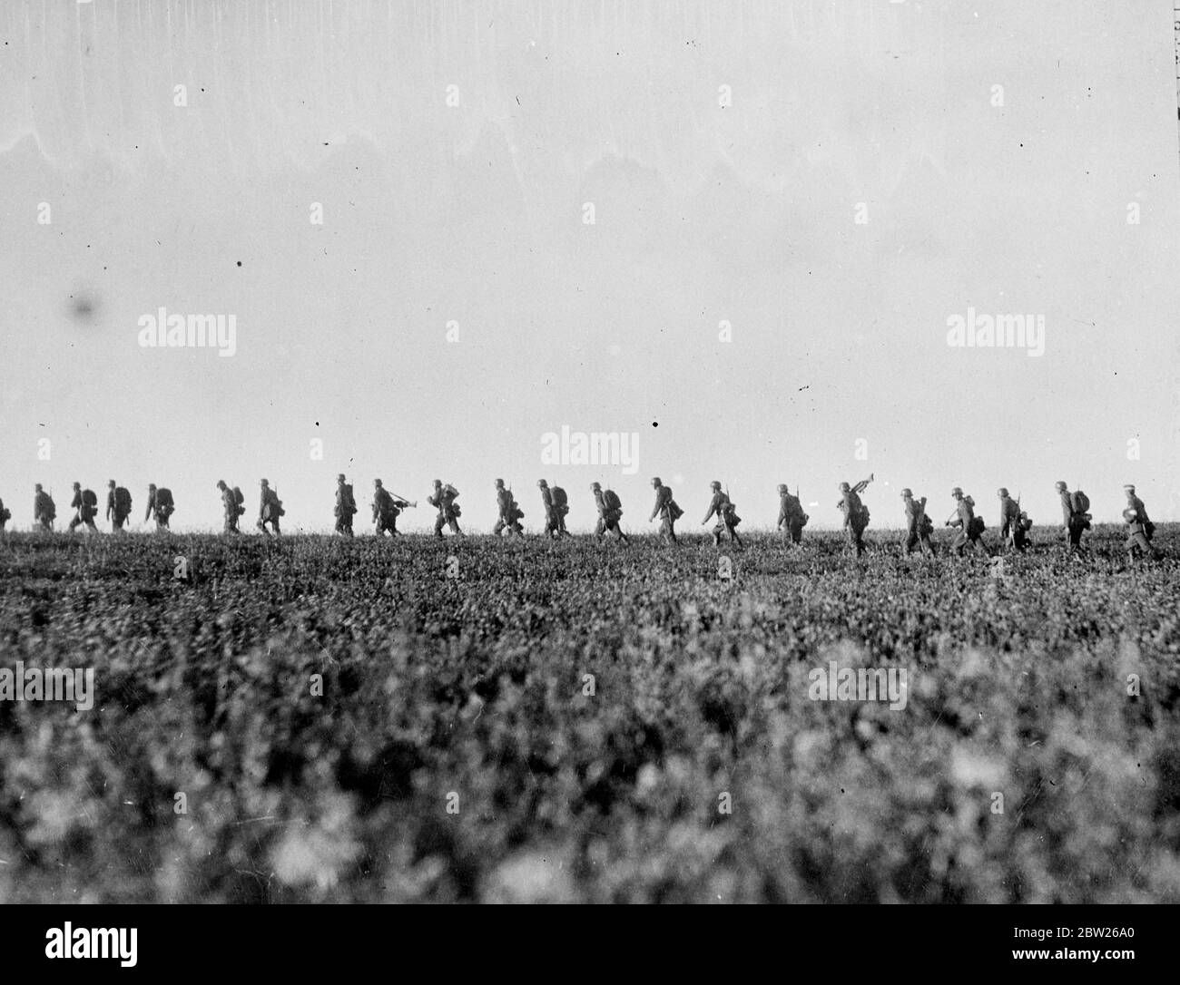 Germany in a state of 'war' as big manoeuvres start, 750,000 men called to colours. Manoeuvres on a vast scale that they have caused alarm in many parts of Europe has started in Germany and will last 10 weeks. Among the dramatic manoeuvres taken by the authorities have been the calling to colours of 750,000 reservists at the requisitioning of food, horses and motor vehicles. The areas where the exercise are taking place will be virtually under martial law during the period of the manoeuvres. Photo shows, infantryman on the move across country during the German manoeuvres. 15 August 1938 Stock Photo