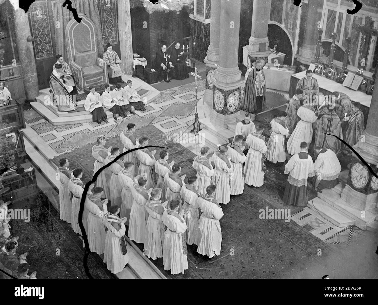 45 young priests ordained as missionaries at Westminster Cathedral. Forty Five young Roman catholic priests who are to go all parts of the world were ordained as missionaries by Cardinal Hinsley, Archbishop of Westminster, at Westminster cathedral. Photo shows, Cardinal hinsley anoiting the priests during the ceremony. 9 July 1938 Stock Photo