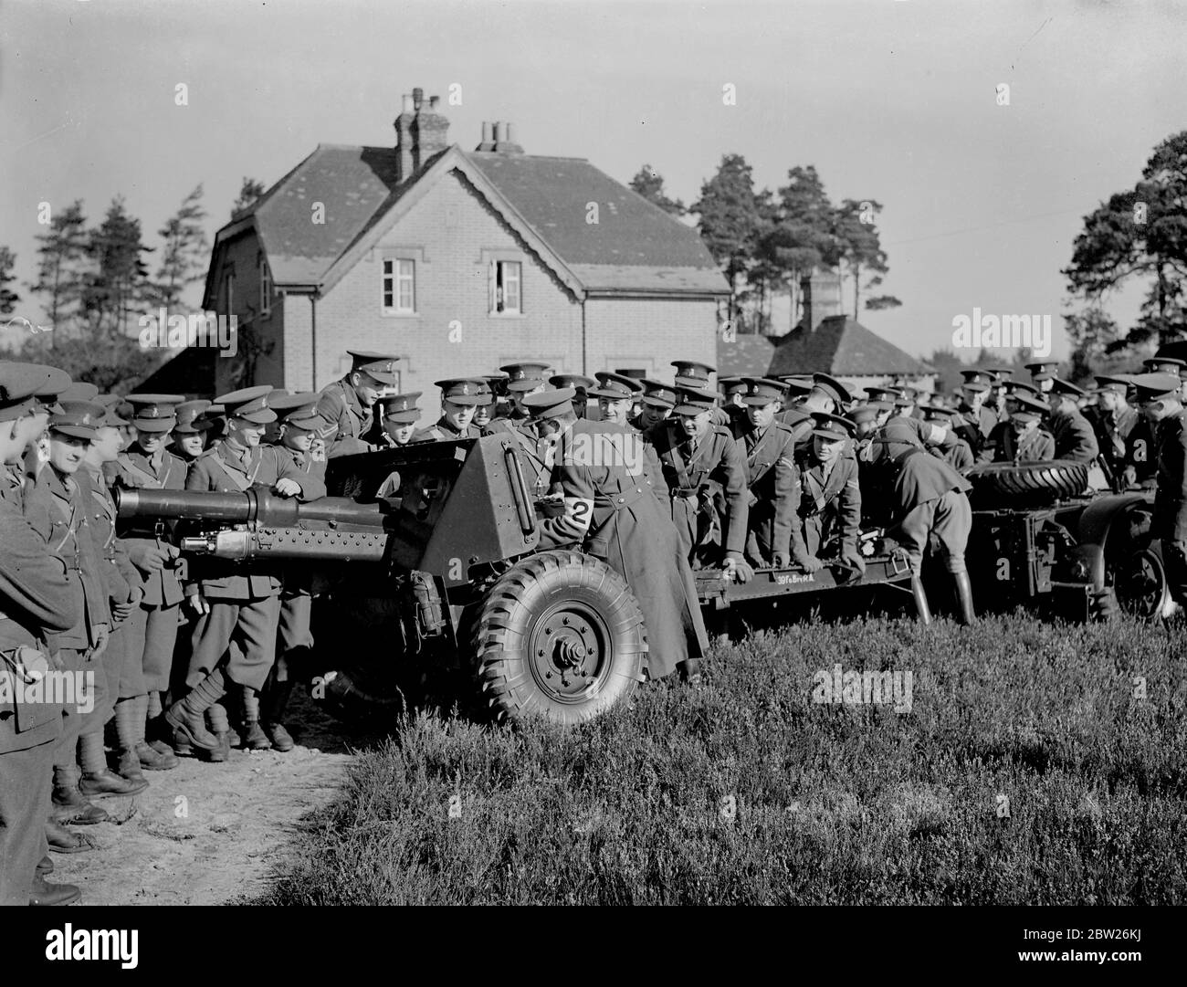 Military cadets see artillery in action. A field battery at war strength gave a demonstration near Camberley (Surrey) for instruction of cadets from the Royal Military College , (Sandhurst). Photo shows, cadets, inspecting and 18 pounder, near Camberley during the demonstration 2 March 1938 Stock Photo